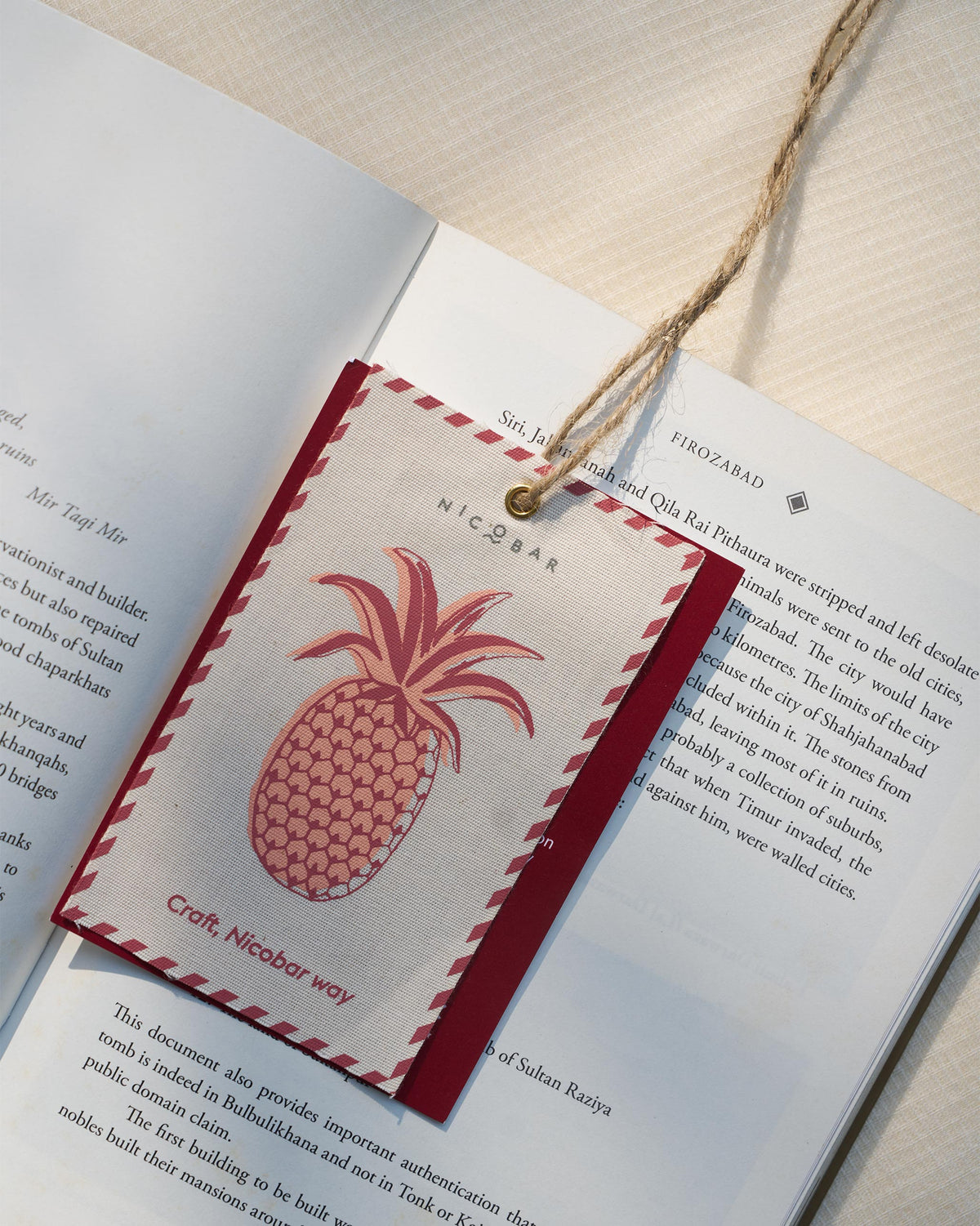Nicobar fabric tag with a pink pineapple print and Craft Nicobar way text.