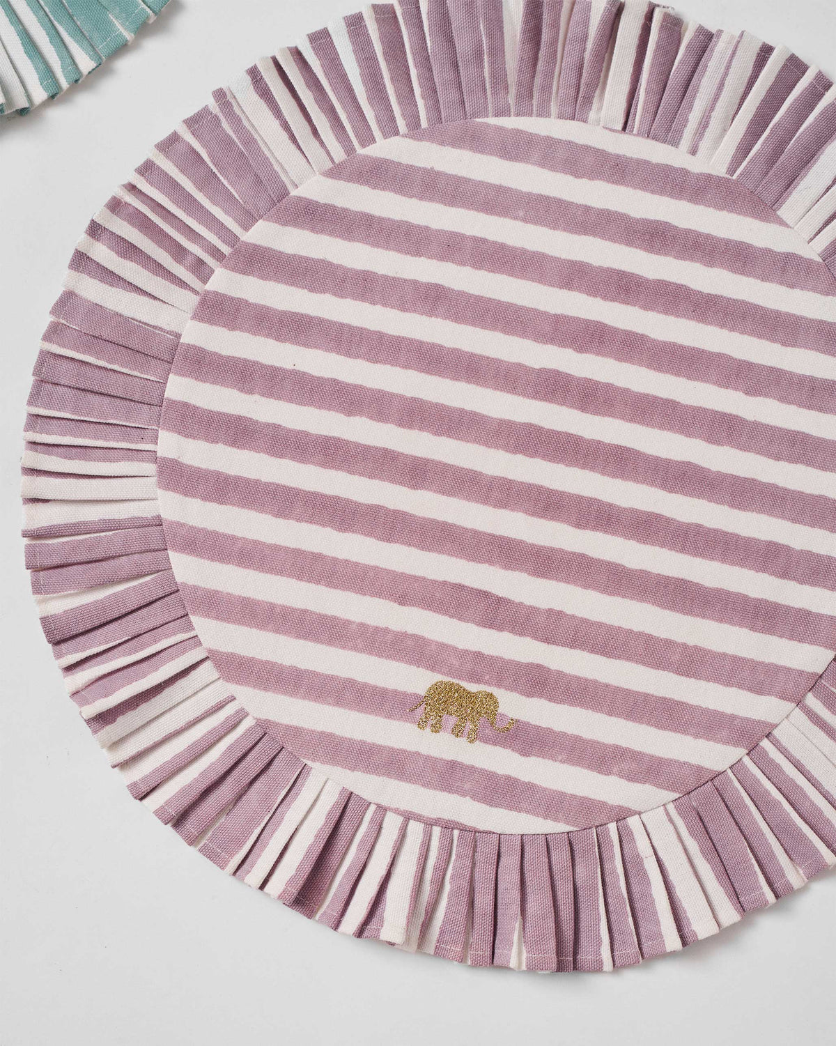 Mauve striped Yamuna placemat with a pleated border and gold elephant.
