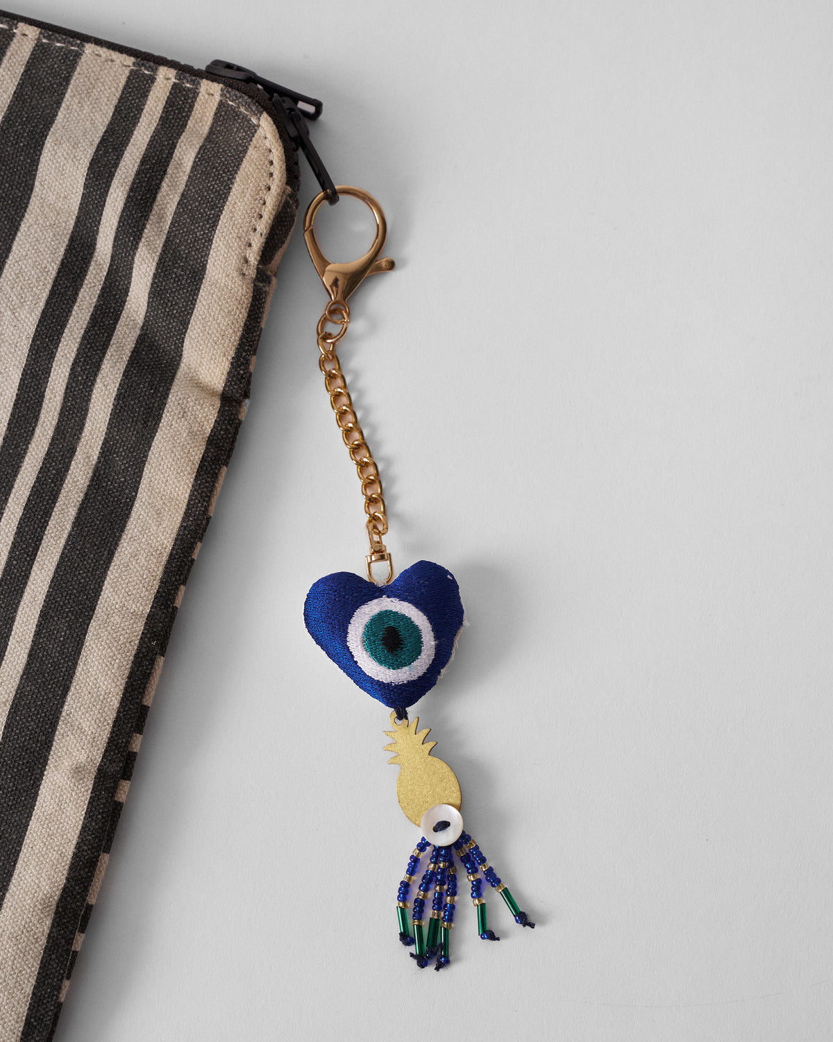 The Ananas charm on a striped pouch.