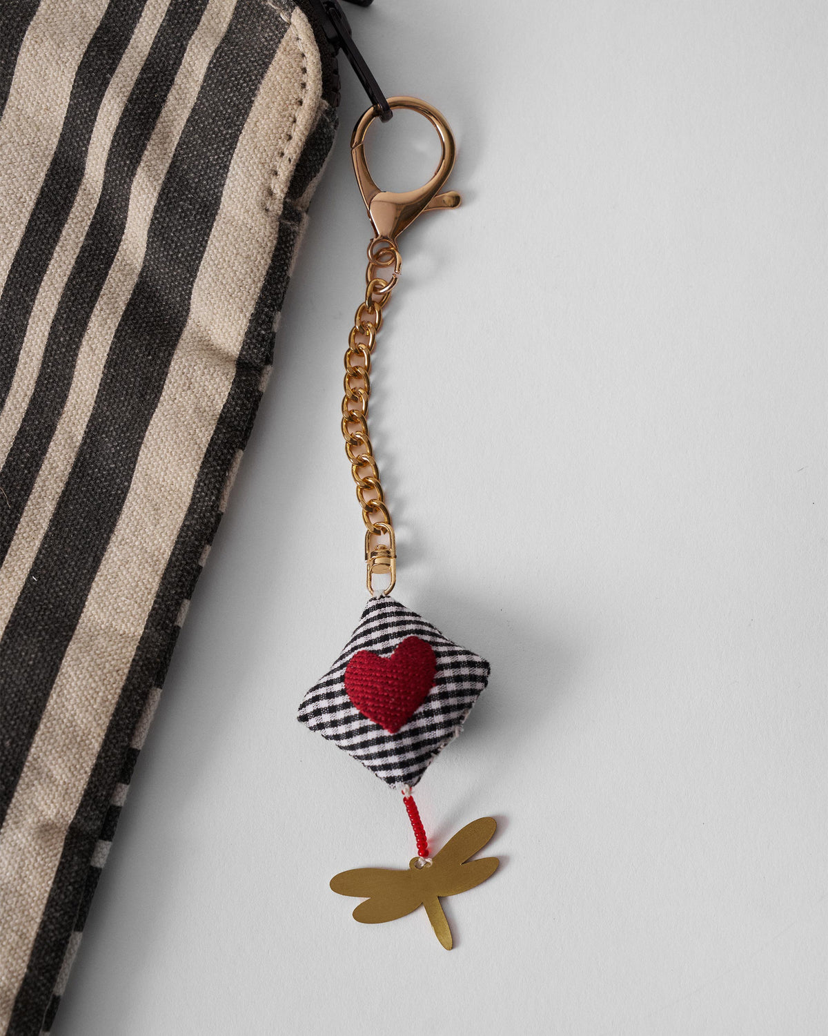 The Dragonfly charm on a striped pouch.