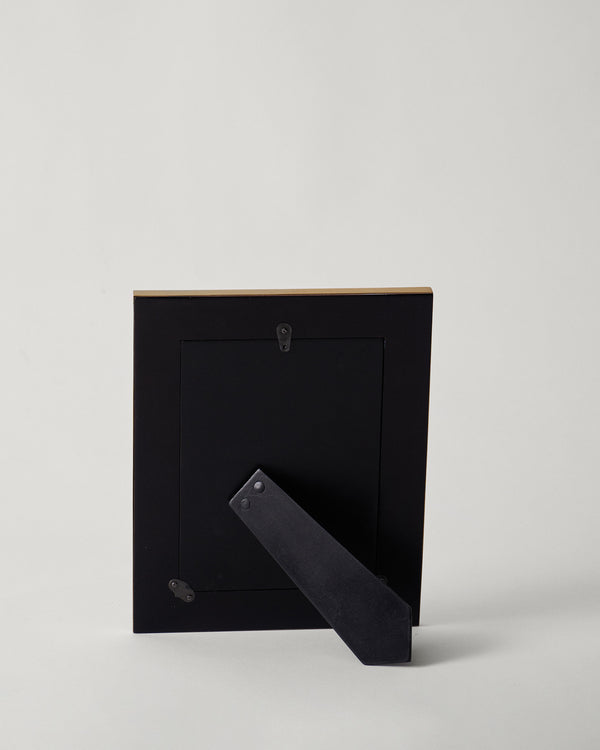 The back of the frame with its stand and hanger