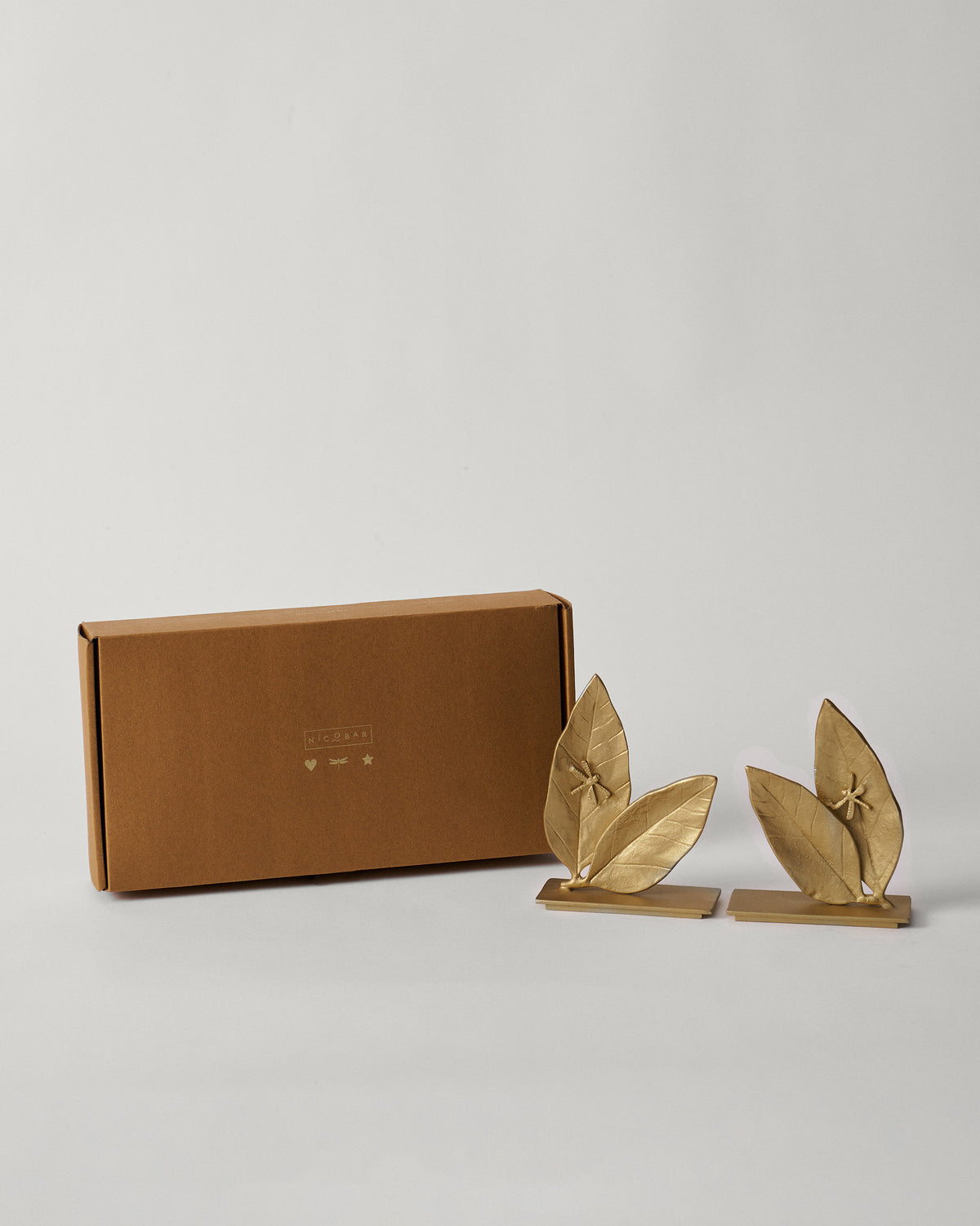 Gold Mogra bookends beside a brown Nicobar box.