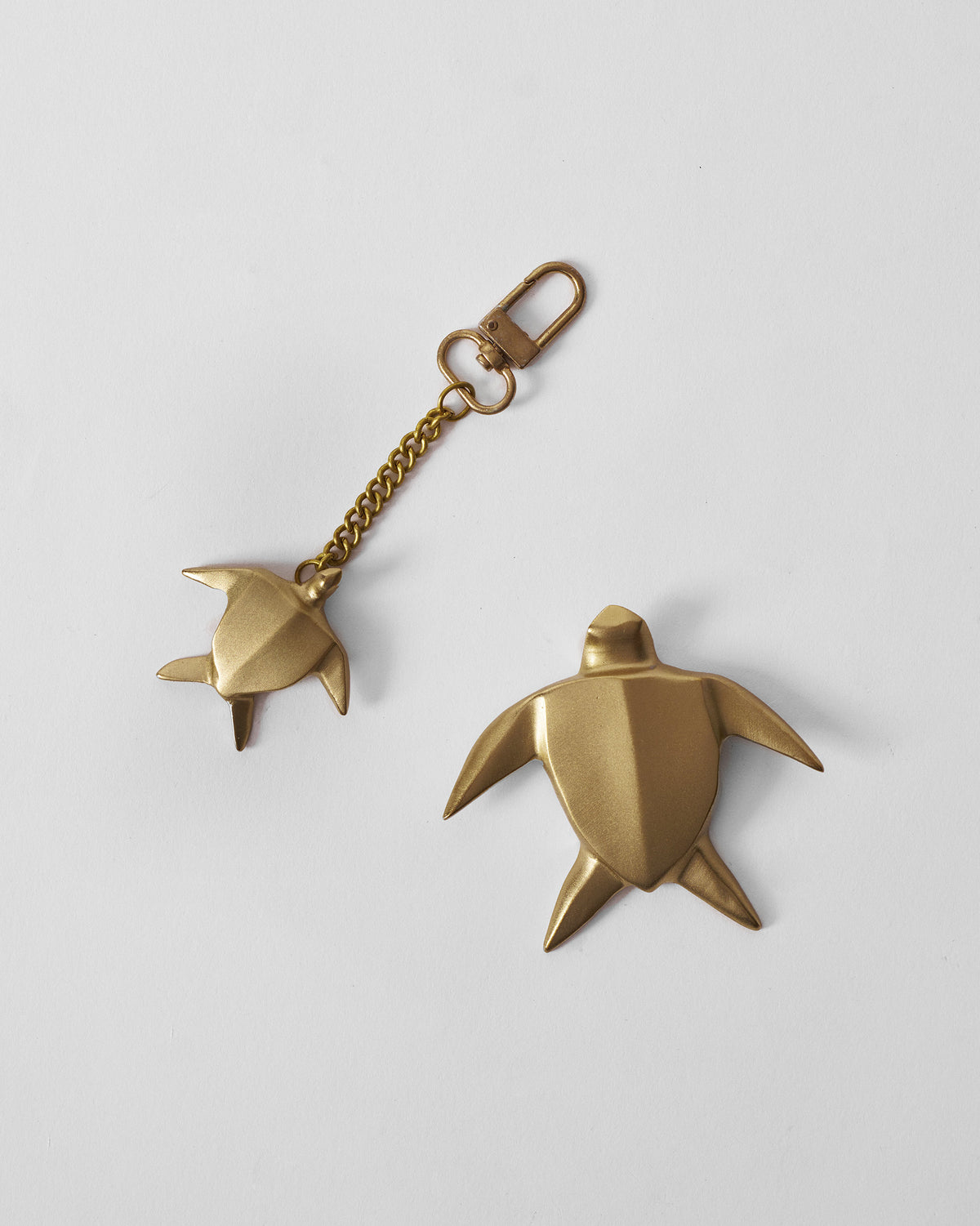 Pair of matte gold turtle keychain and matching turtle paperweight.