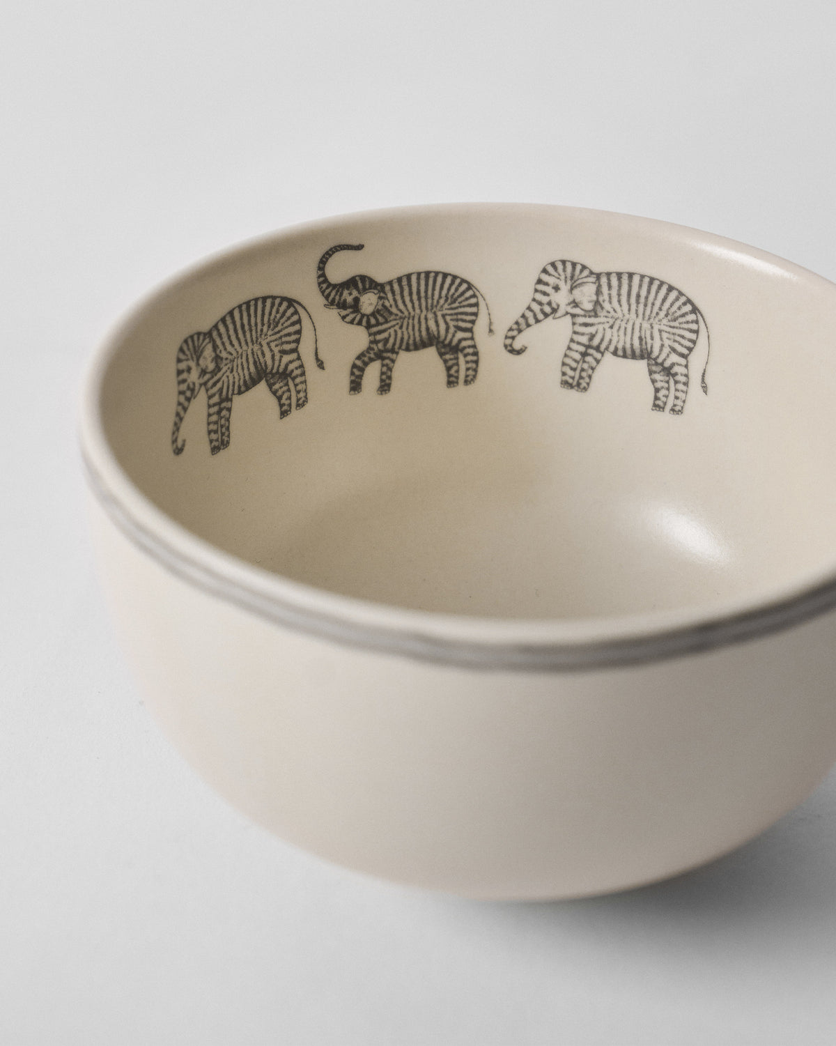 Close-up of a Tusk Katori showing three striped elephant motifs around the inside rim.