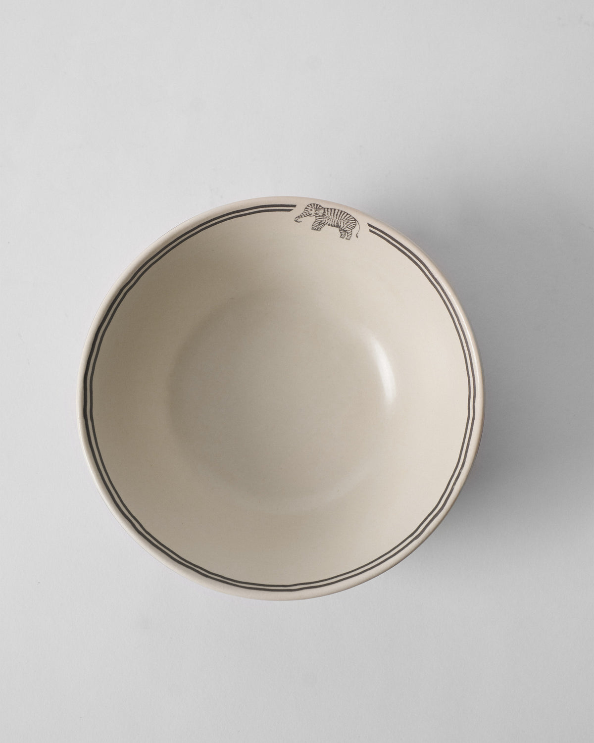 Overhead view of the Palm Bloom Bowl with a small animal on its rim.