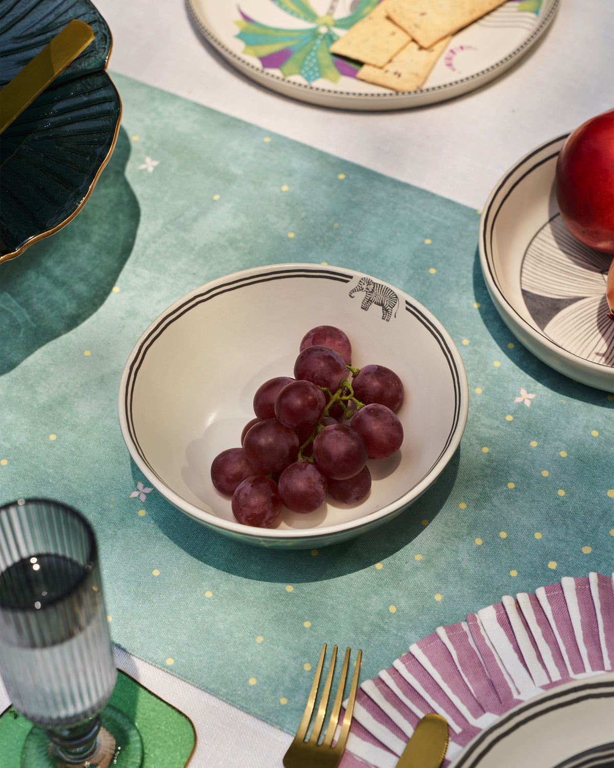 Palm Bloom Bowl with a small elephant motif, shown on a set table.