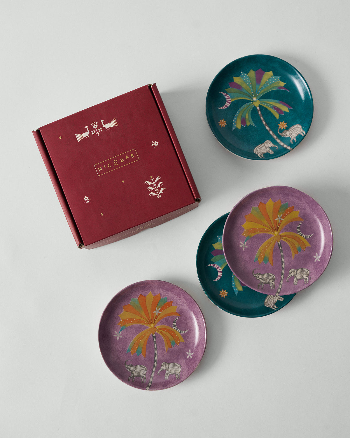 Palm Bloom tea plates arranged with a maroon Nicobar gift box.