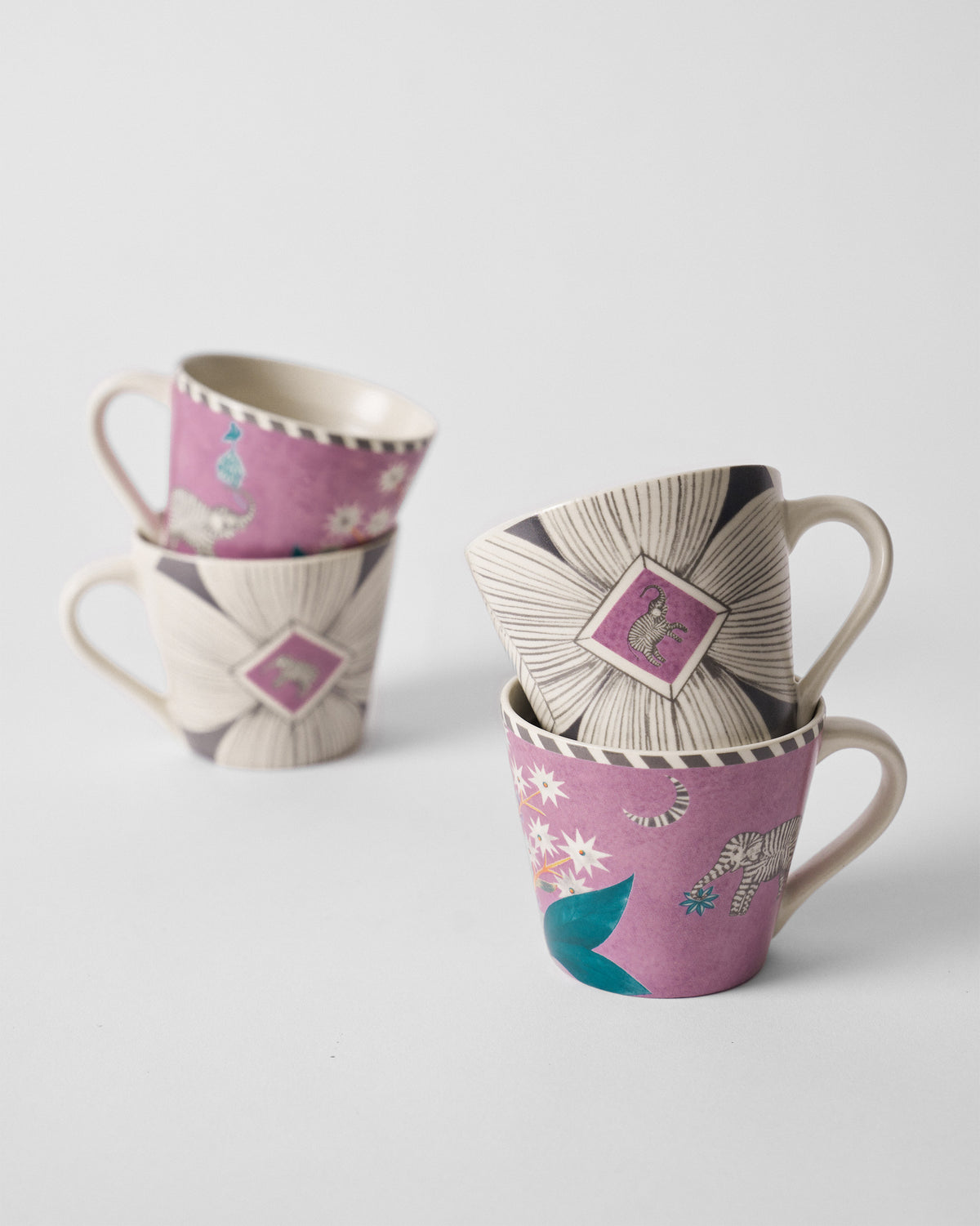 Mogra Bloom espresso mugs stacked in pairs, showing magenta elephant and cream floral designs.