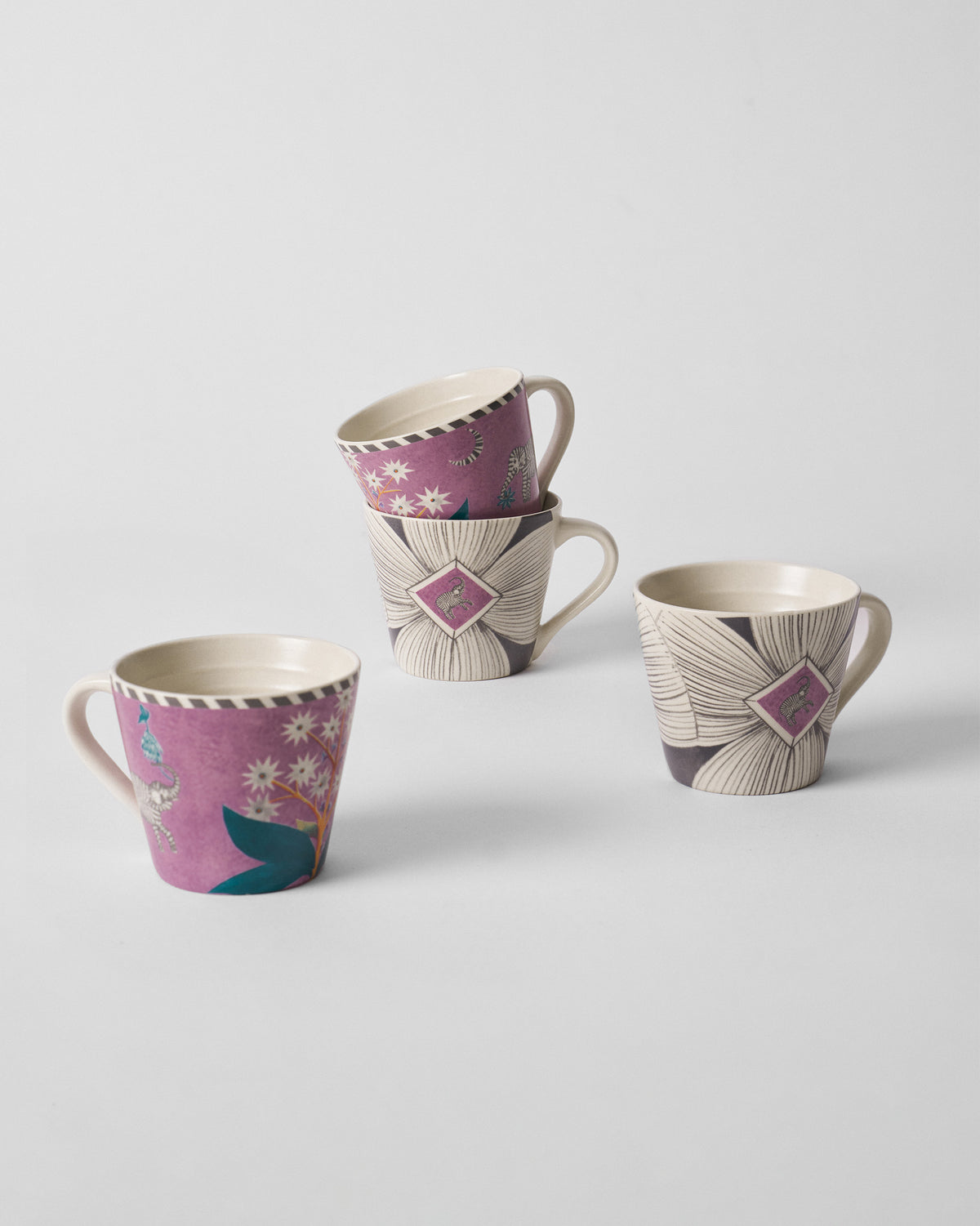 Group of four Mogra Bloom espresso mugs with magenta elephant and cream floral prints.