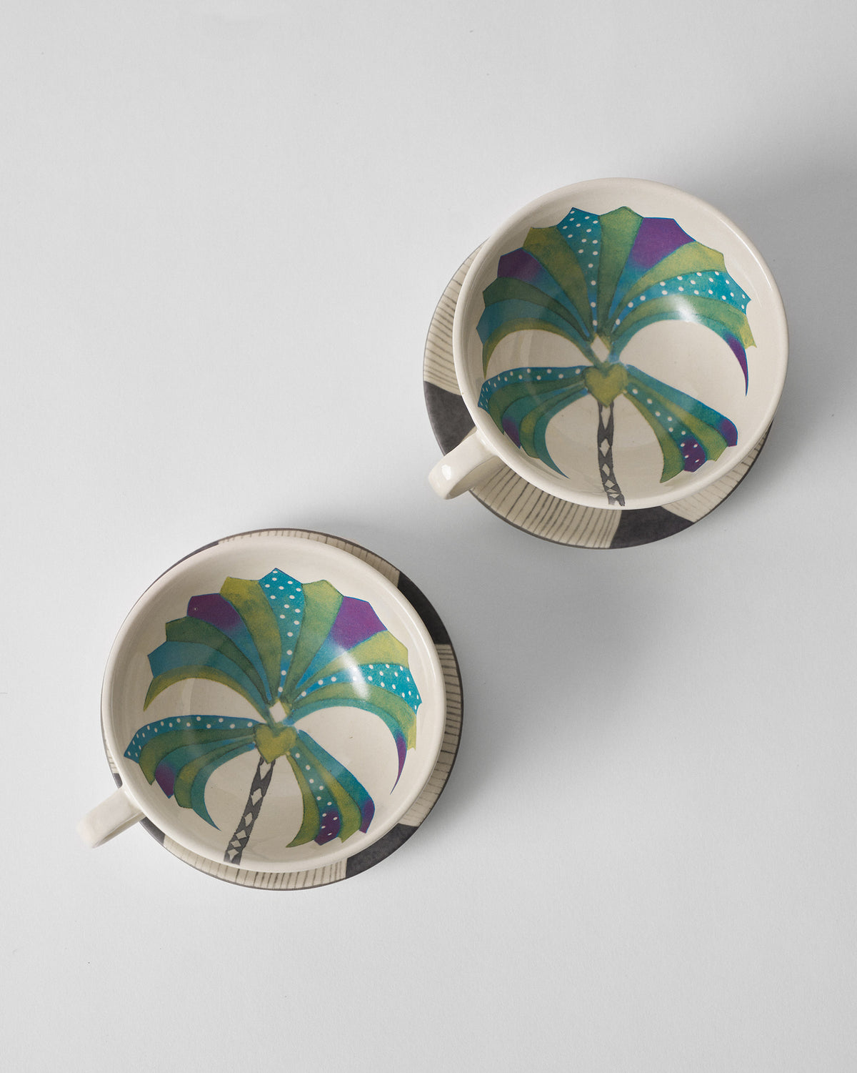 Overhead view of Palm Bloom cups showing colorful palm interiors on striped saucers.