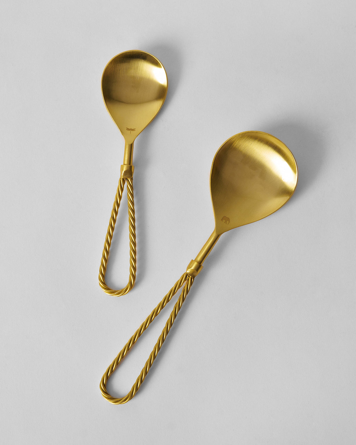 Pair of brushed gold Tusk serving spoons with rope-loop handles.