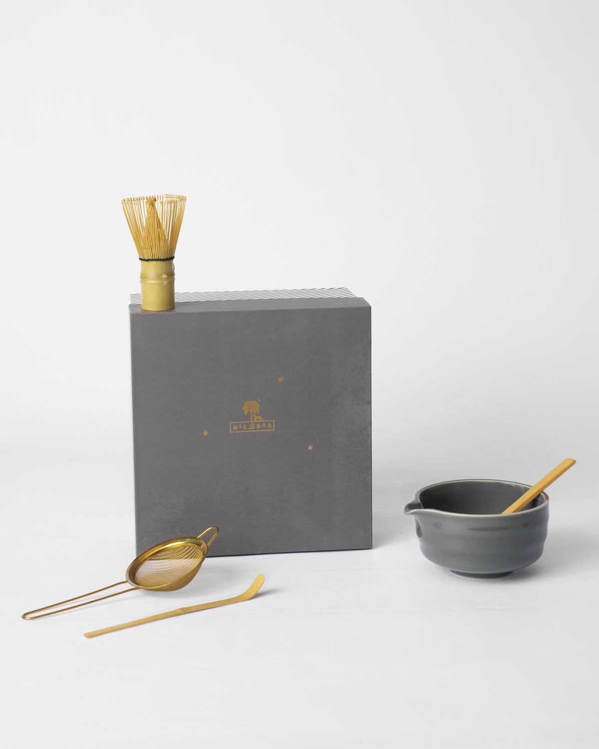 Palm Bloom Matcha set with bamboo whisk, grey bowl, gold strainer, and scoop.