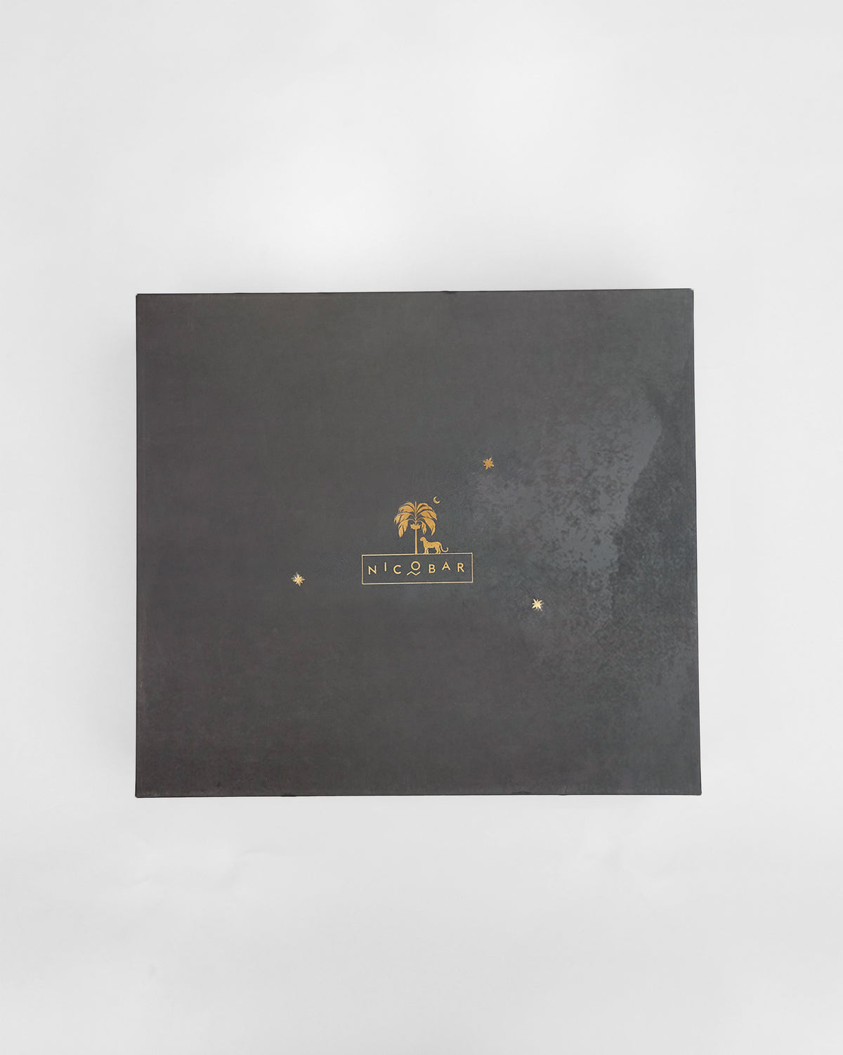 Closed charcoal Mehfil bar gift box with gold Nicobar logo.