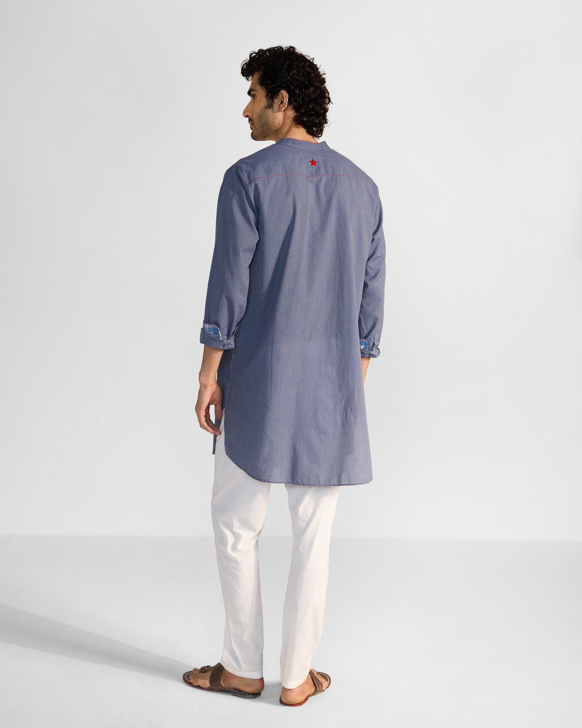 Back of a navy and white striped Nysa Kurta with a red embroidered star.
