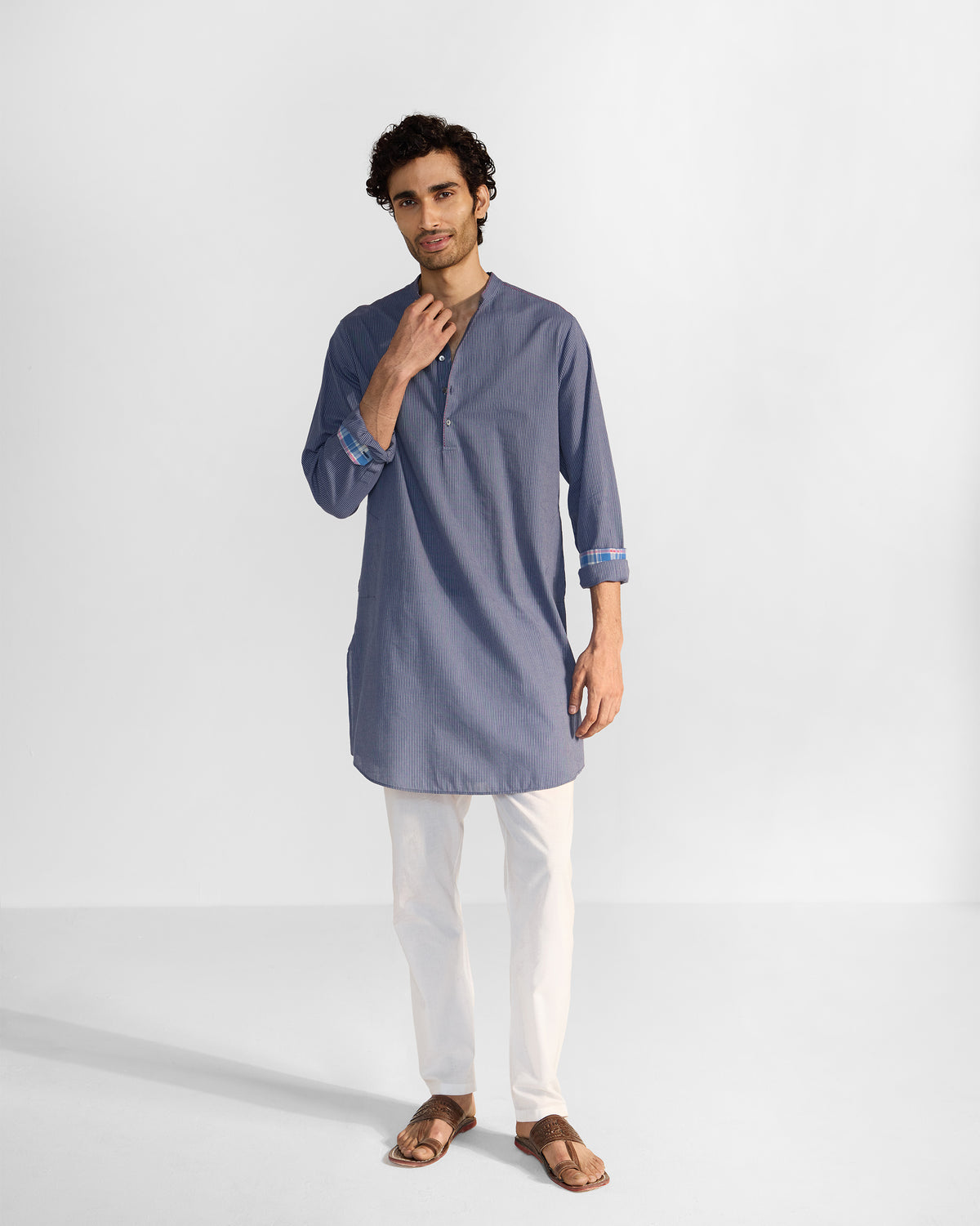 Navy and white striped Nysa Kurta worn with sleeves rolled to show plaid cuff lining.