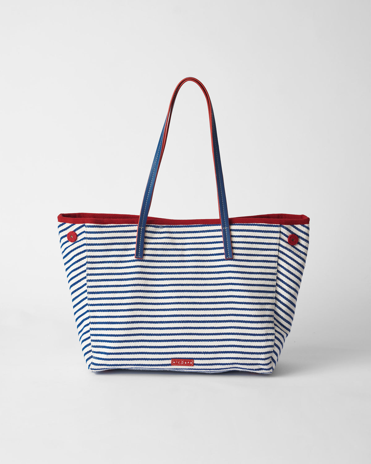 Blue and white striped Kira Bag with red trim and blue straps.