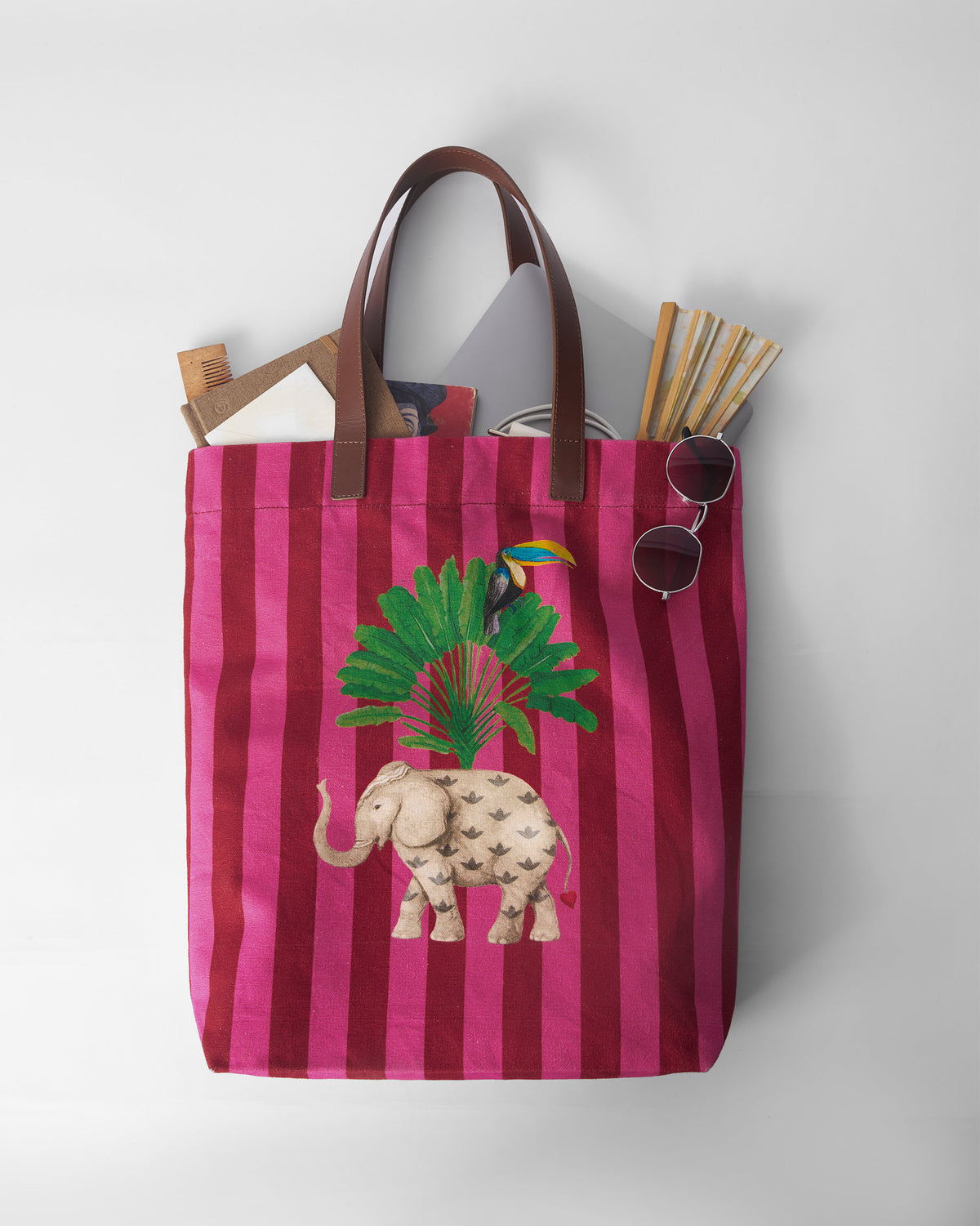 Pink and maroon Mukayu city tote filled with everyday essentials.