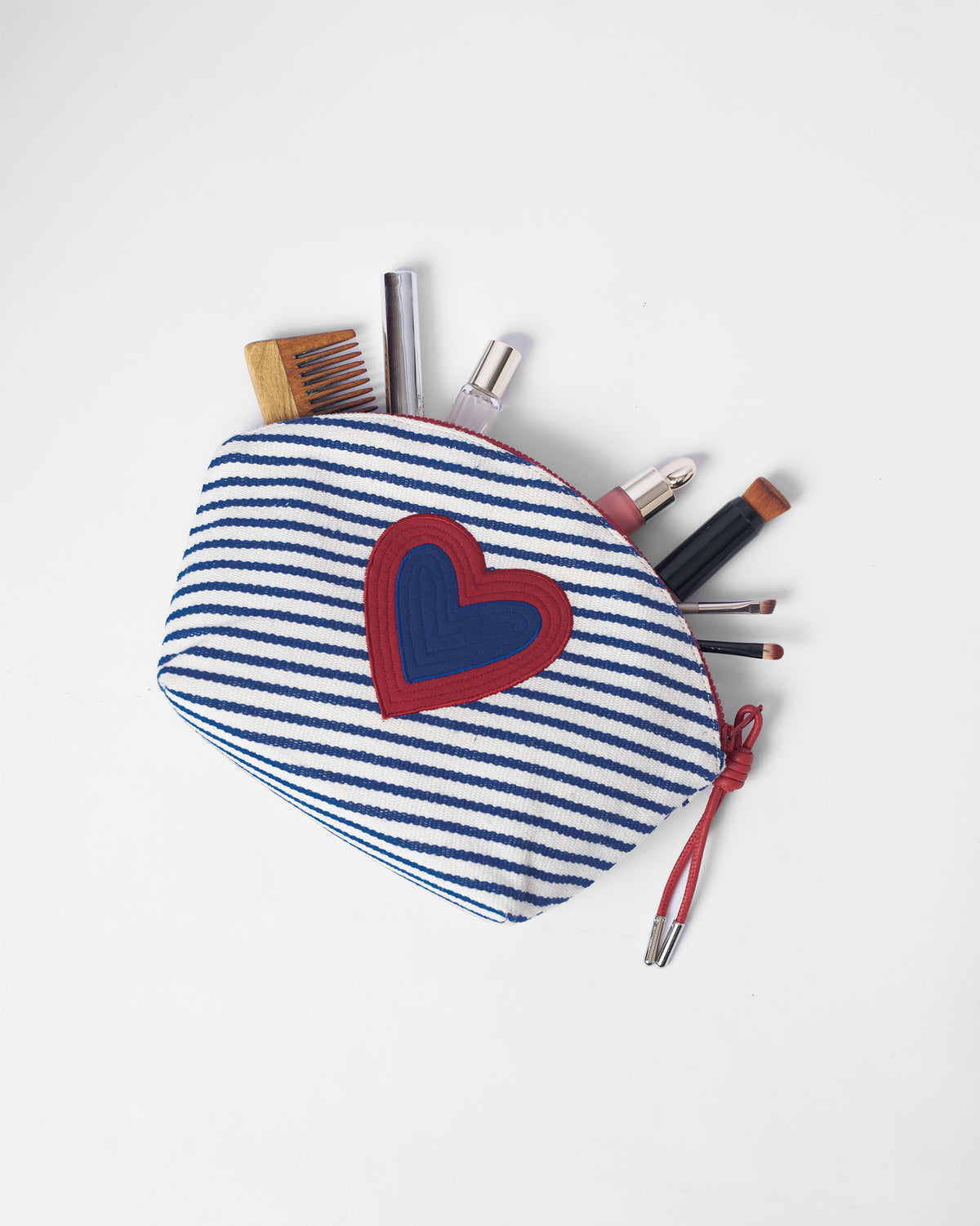 Blue and white Kira Pouch packed with small everyday essentials.