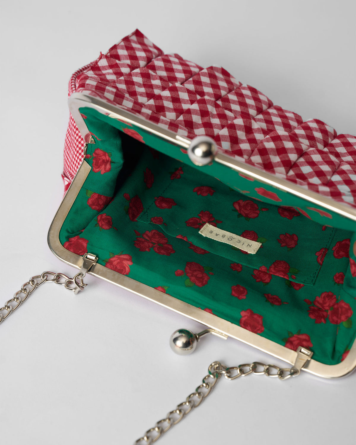 Open Pleated Muse Clutch showing the green rose lining and silver clasp.