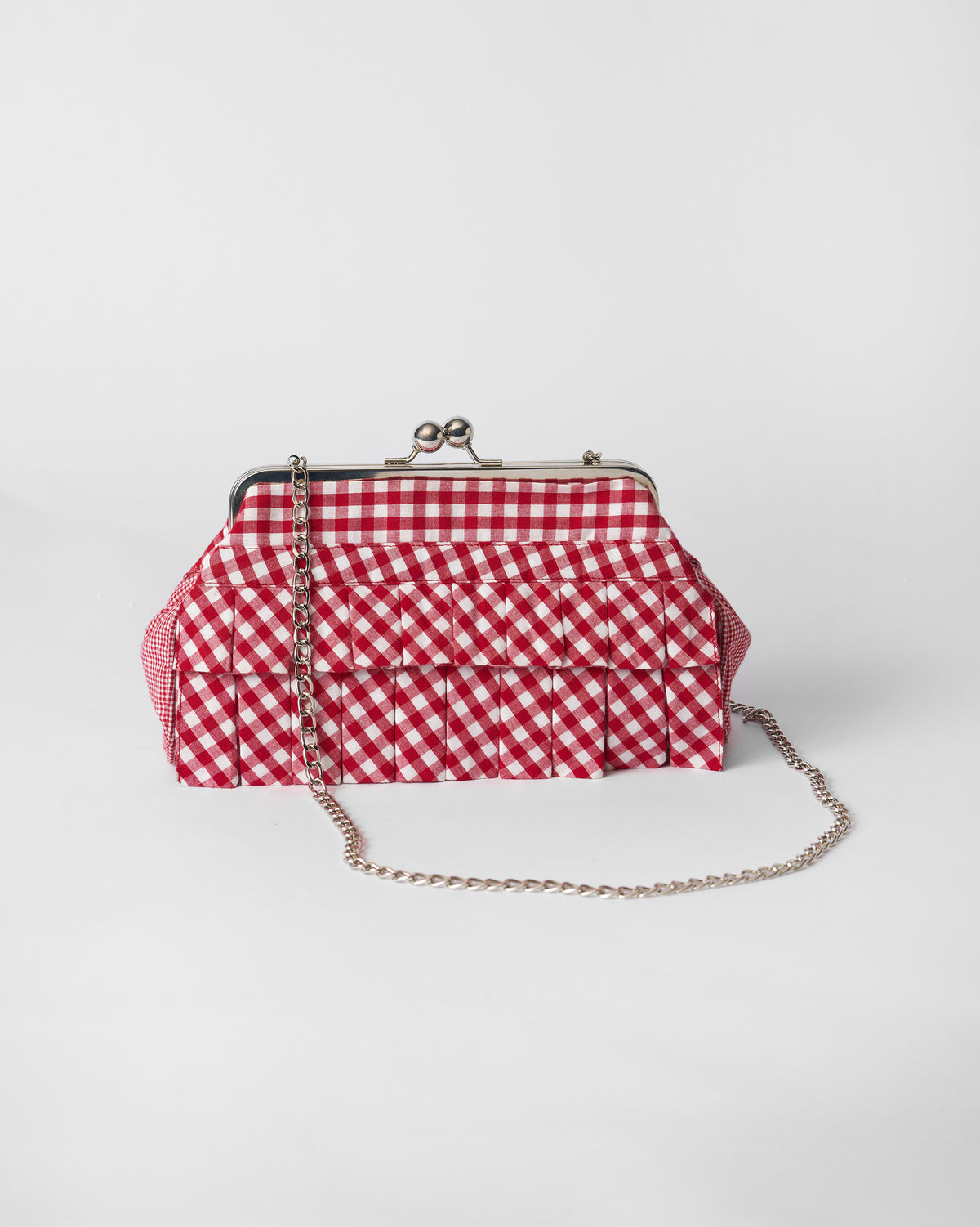 Red and white gingham Pleated Muse Clutch with tiered pleats and a silver chain.