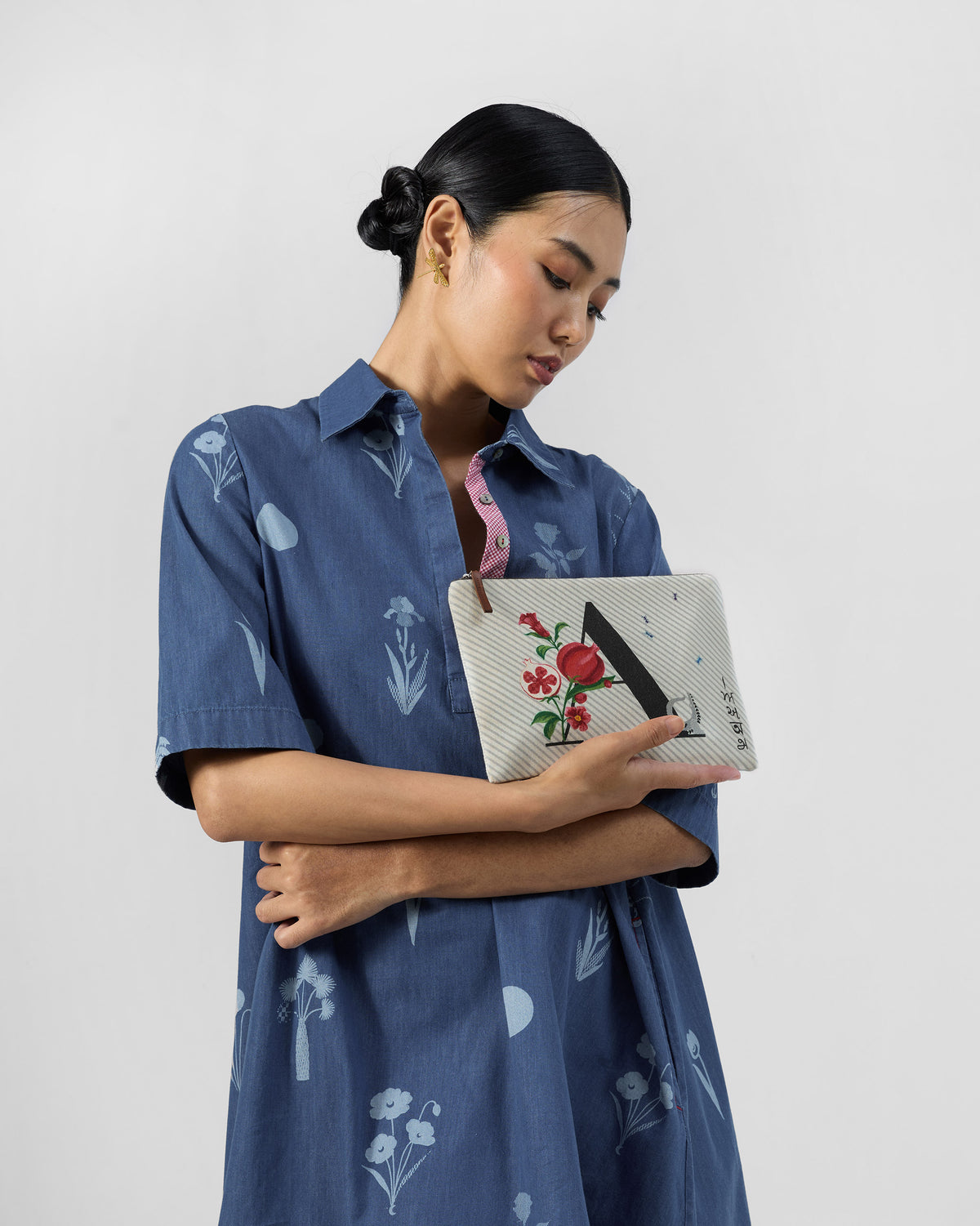 Person holding an ivory Anaar Pouch with a letter A and pomegranate print.