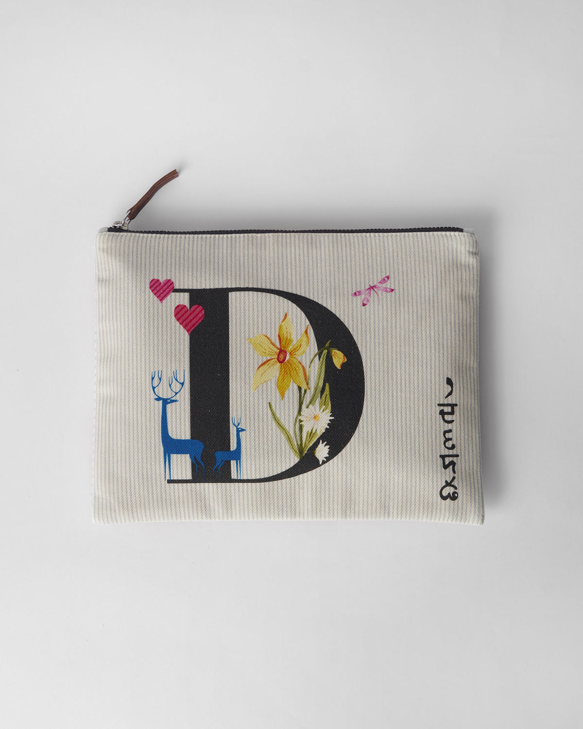 Ivory Dil Pouch with a black D print, flowers, deer, and pink hearts.