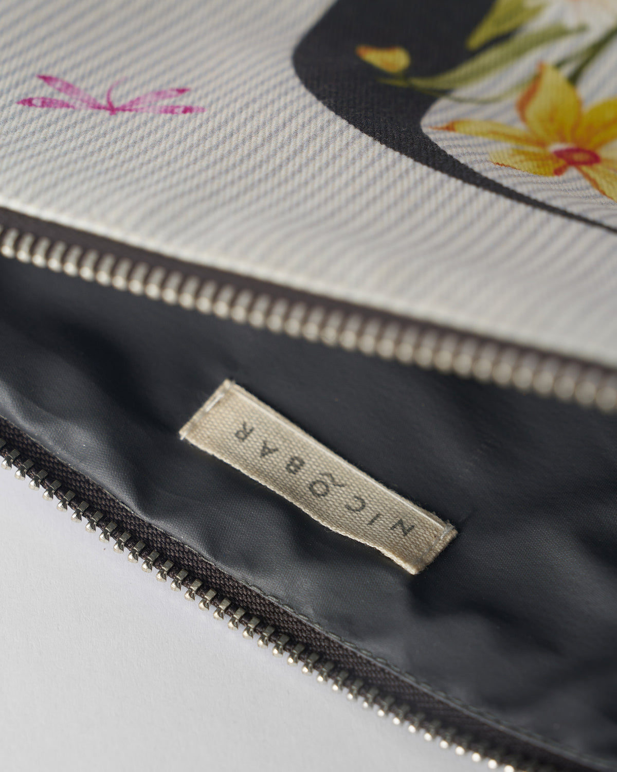 Open ivory Dil Pouch showing the dark lining and Nicobar label.