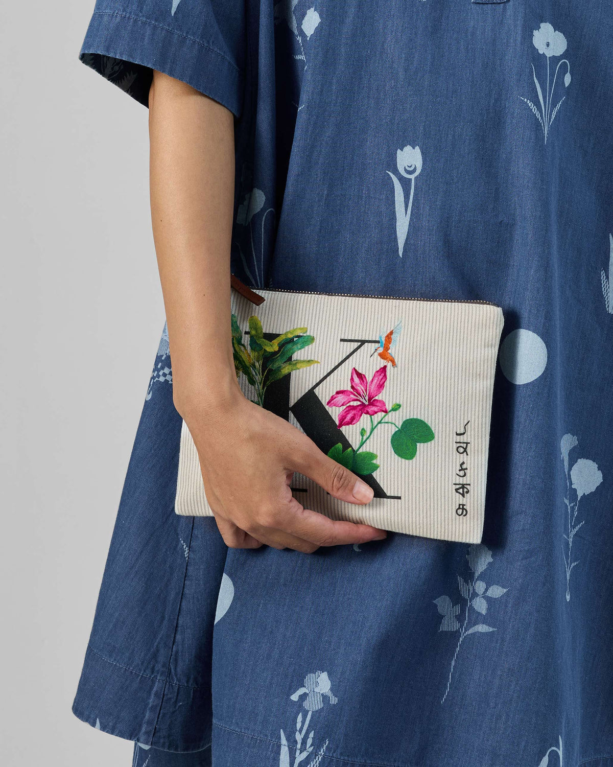 Ivory Kamal Pouch with a black K print, pink flower, and small bird.