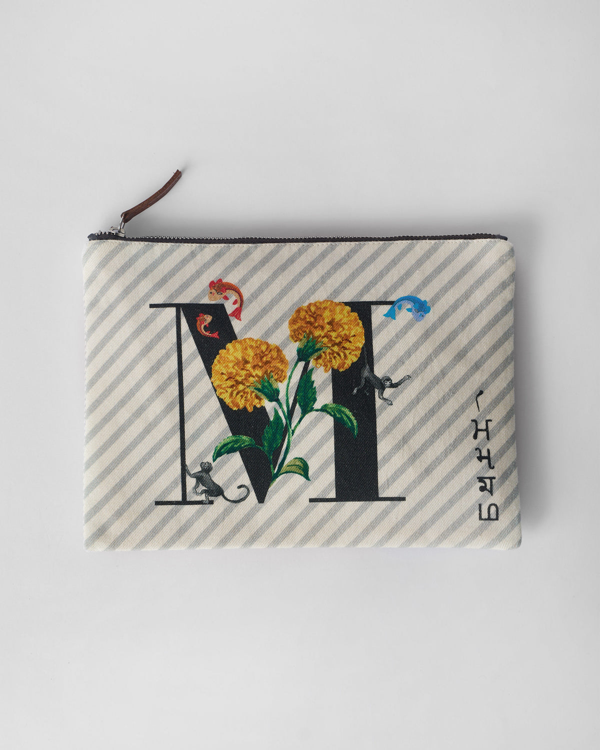 Ivory Machli Pouch with a black M print, yellow marigolds, and fish.