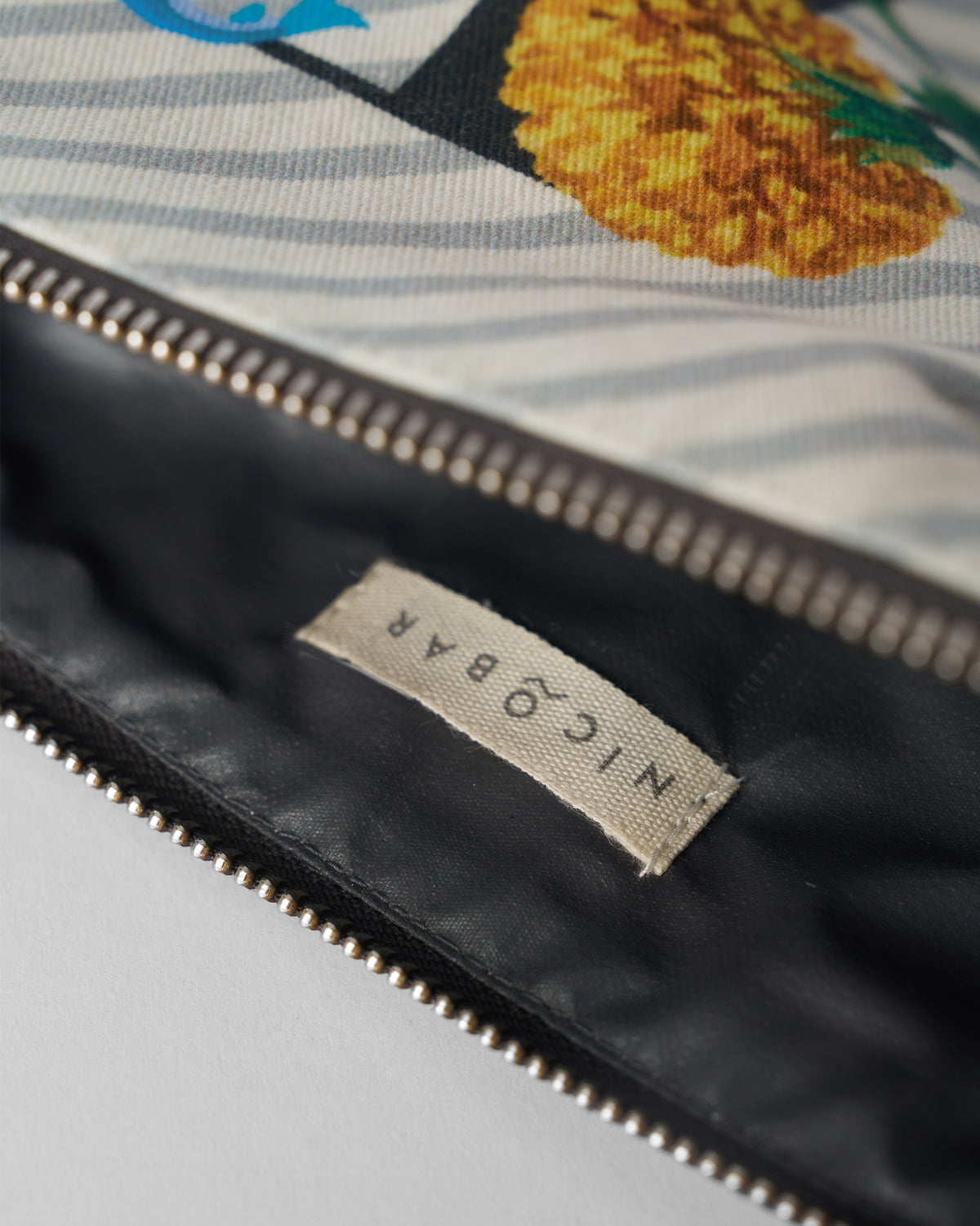 Open ivory Machli Pouch showing the dark lining and Nicobar label.
