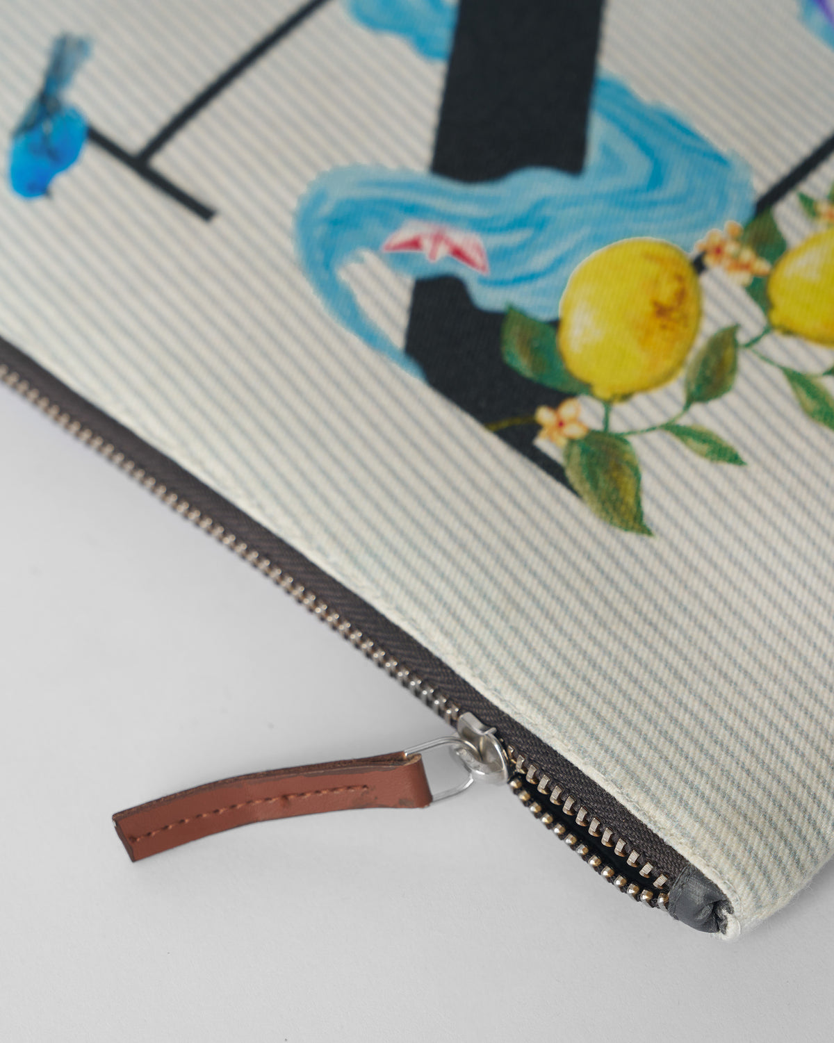 Close-up of the brown leather zipper pull on an ivory Nilambari Pouch.