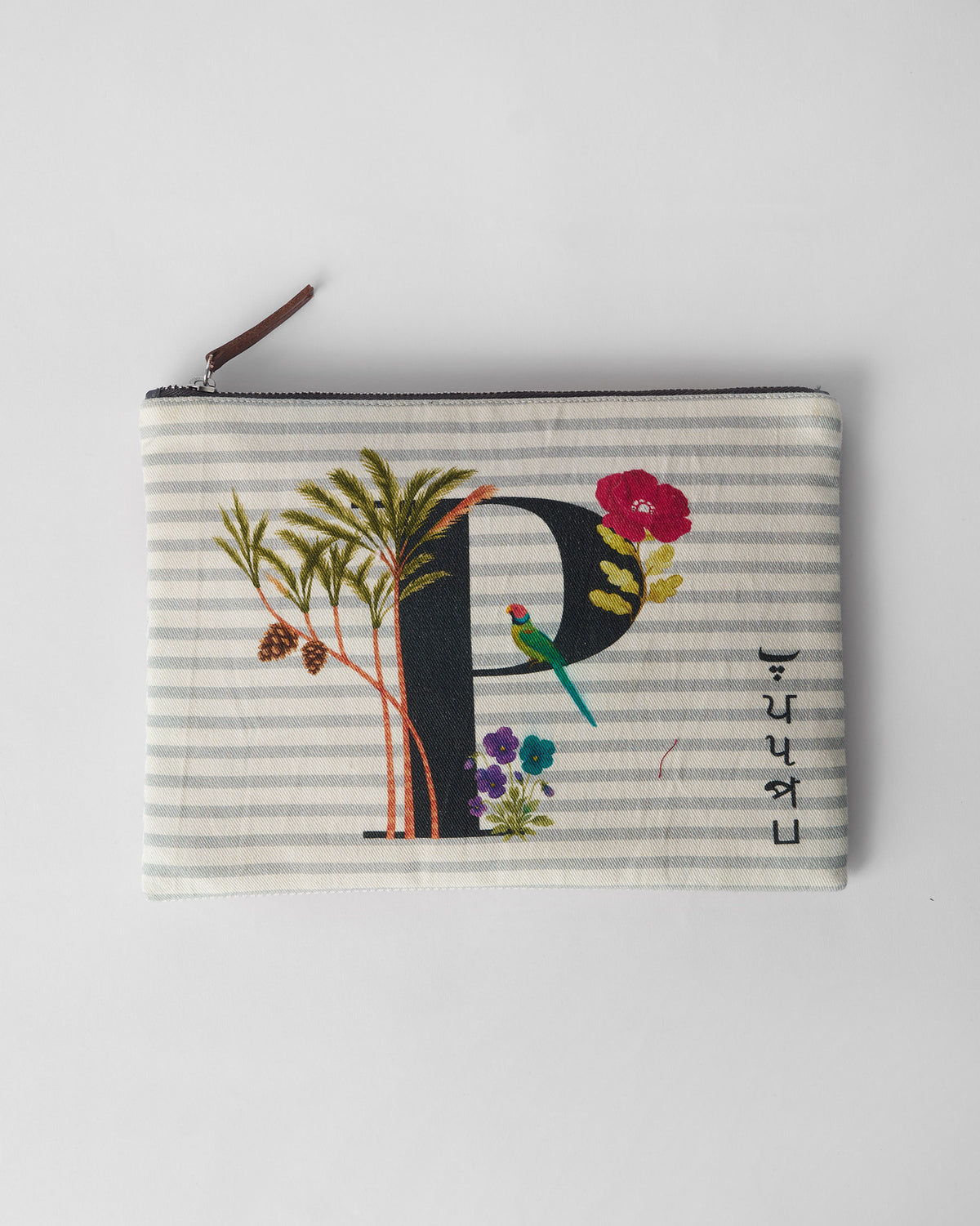Ivory Palash Pouch with a black P print, palm trees, and a small parrot.