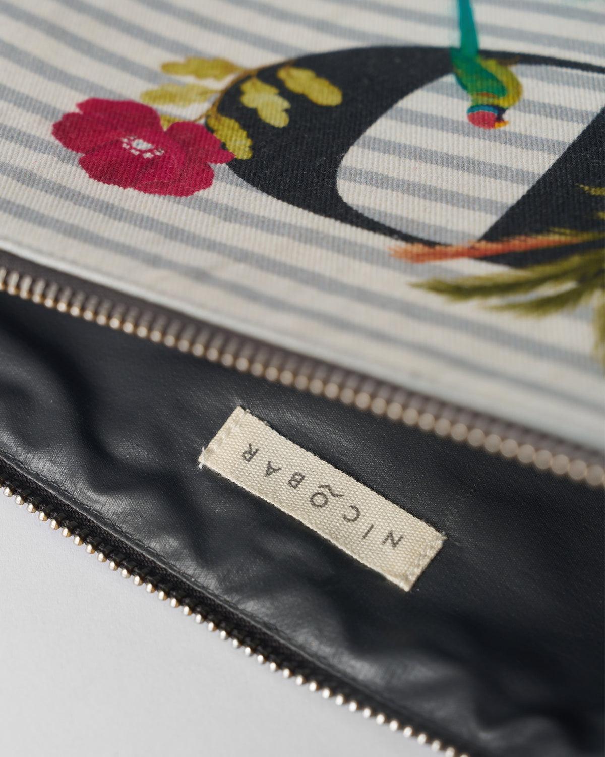 Open ivory Palash Pouch showing the dark lining and Nicobar label.
