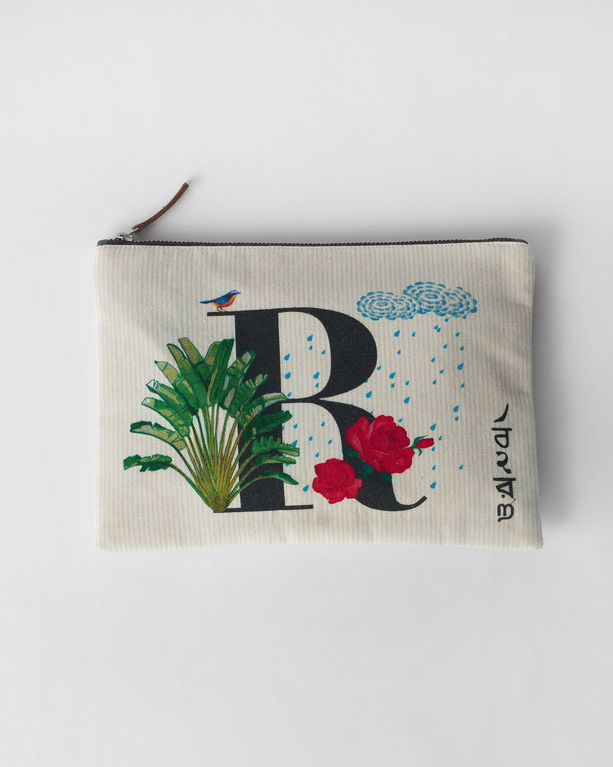 Ivory Rimjhim Pouch with a black R print, red roses, and blue rain clouds.