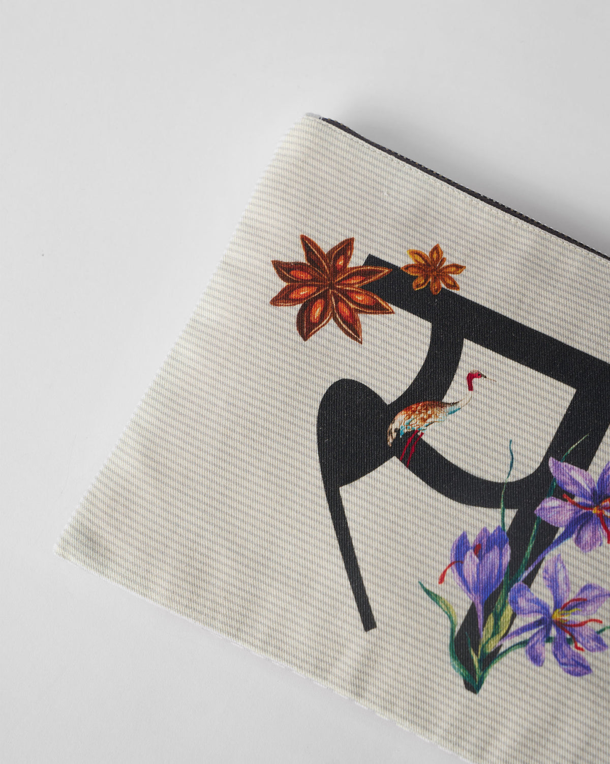 Close-up of the Sitara Pouch showing star anise, a bird, and purple flowers.