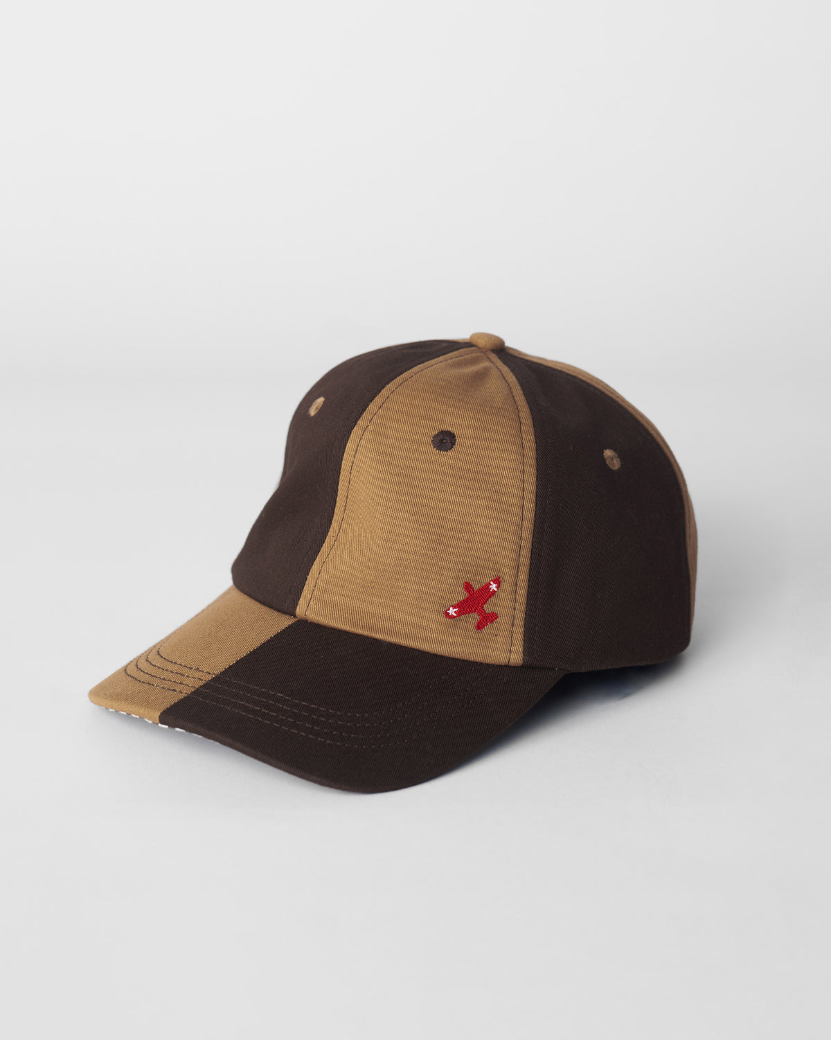 Brown and beige Aero Cap with a red airplane embroidery.