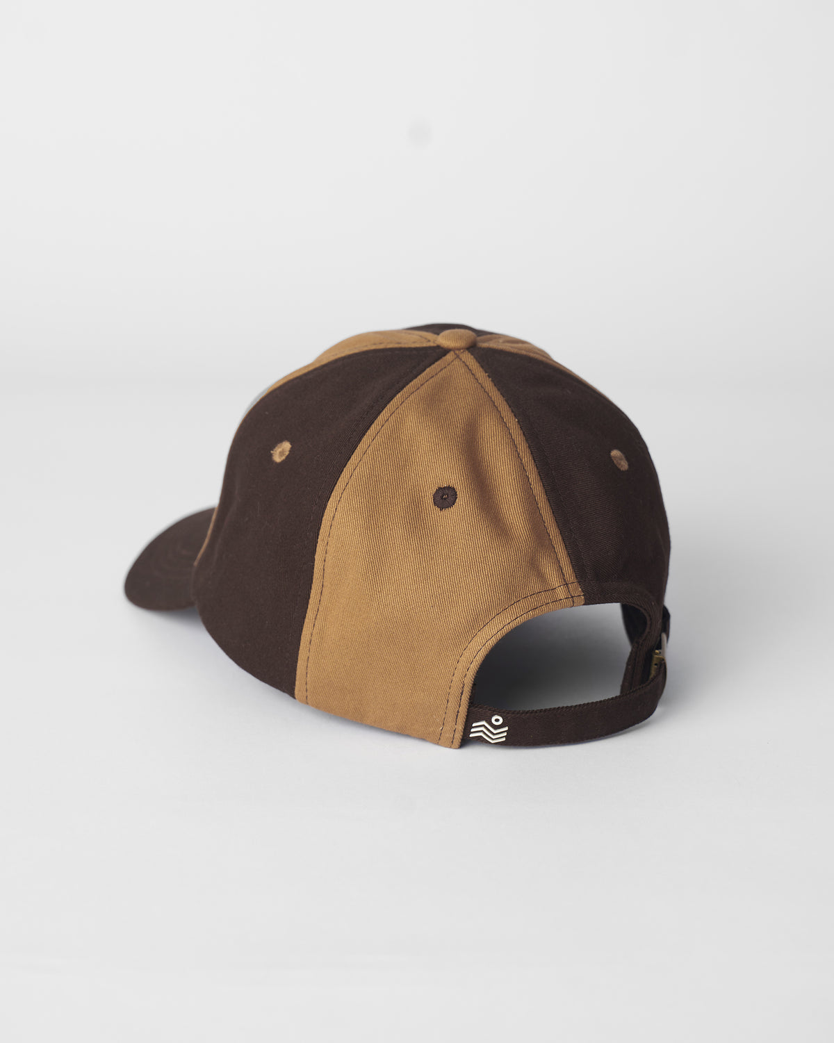 Back of a brown and beige Aero Cap with an adjustable strap.