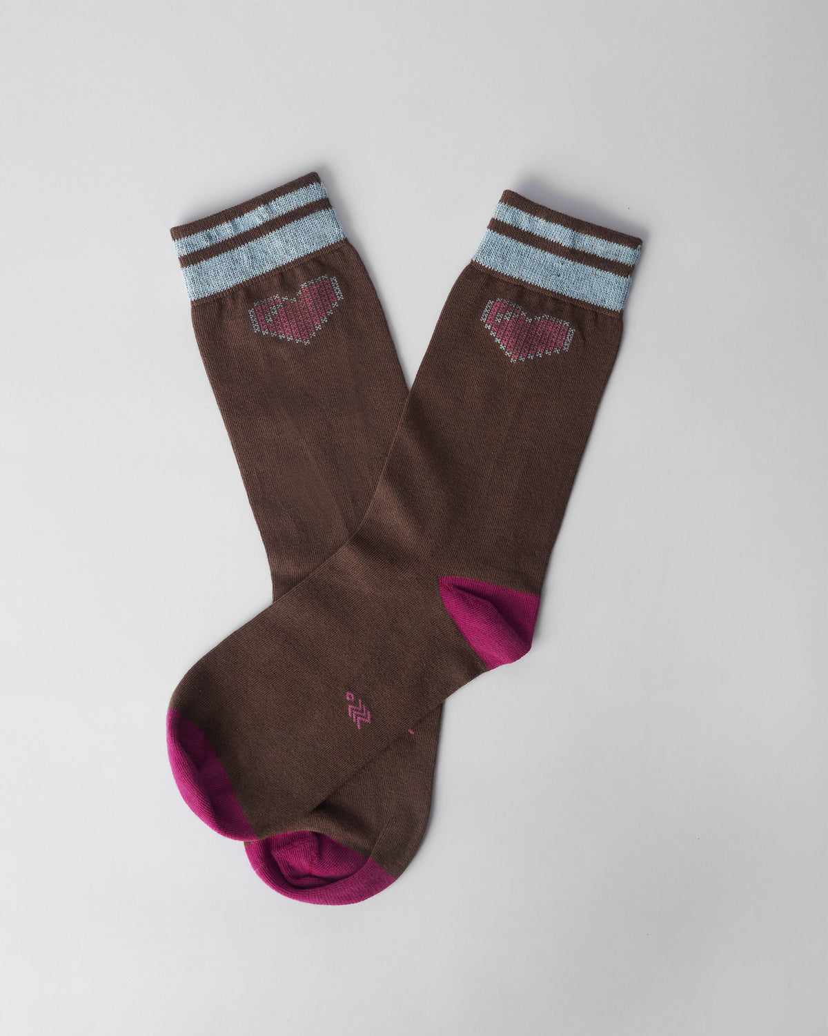 Brown Pixel Heart Socks with fuchsia toes and pink pixel hearts crossed flat.