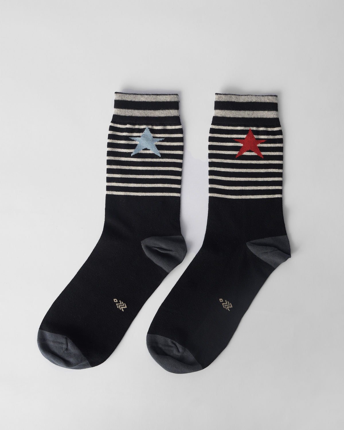 Pair of black Starfly socks with striped cuffs and mismatched blue and red stars.