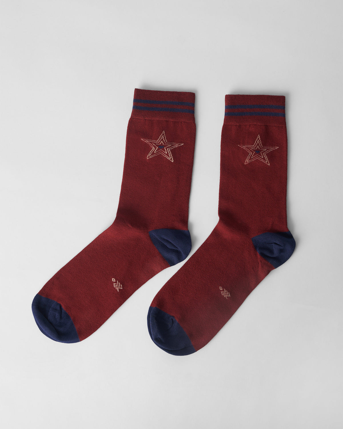 Pair of maroon Starry socks with navy heels and cream star motifs.
