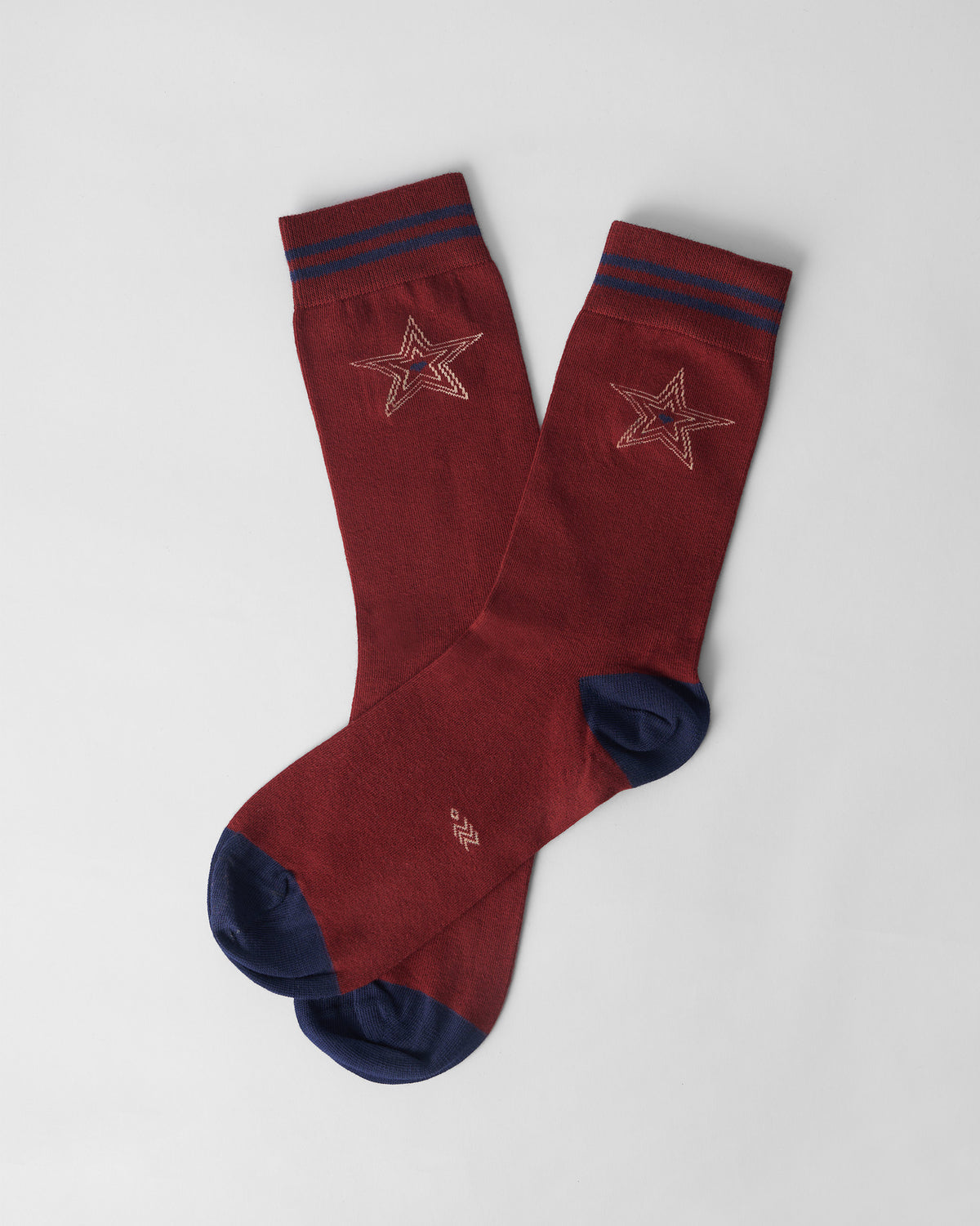 Maroon Starry socks crossed flat, showing navy accents and star embroidery.