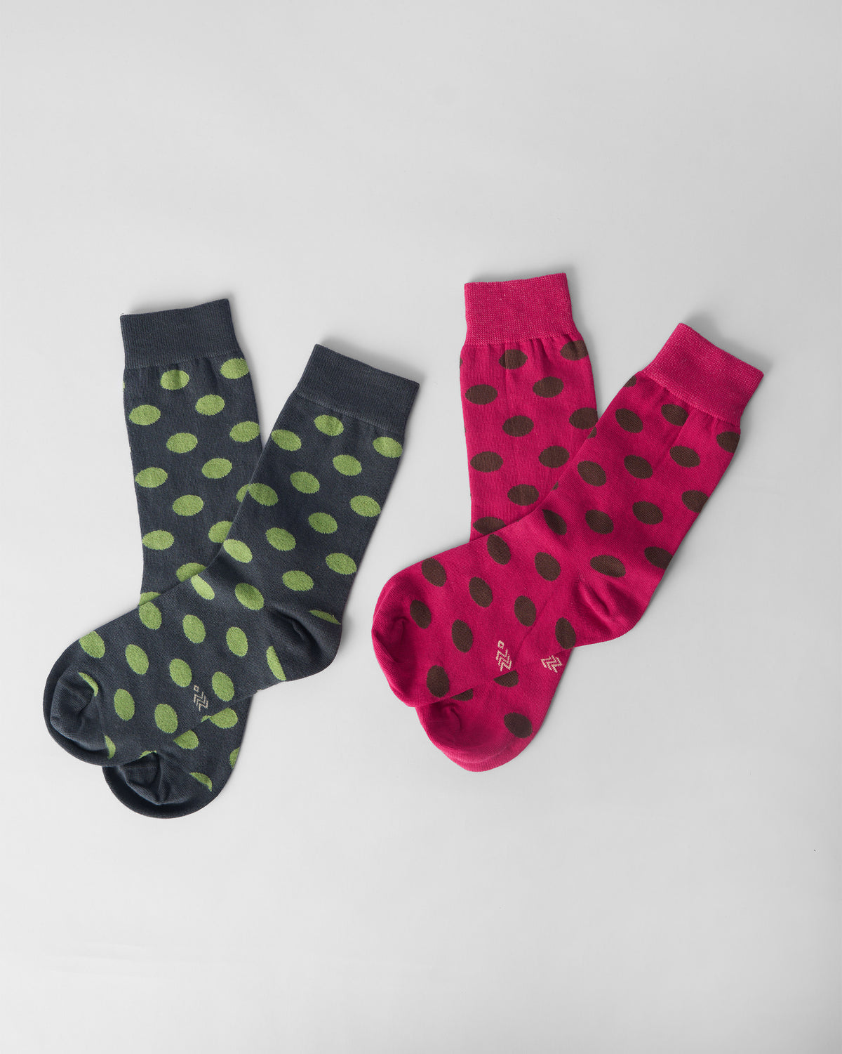 Pair of fuchsia and charcoal Polka Love socks with polka dots.