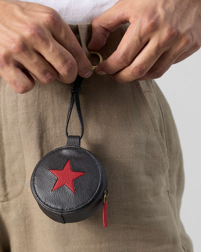 Black and red Nova Charm with a red star clipped to a belt loop.