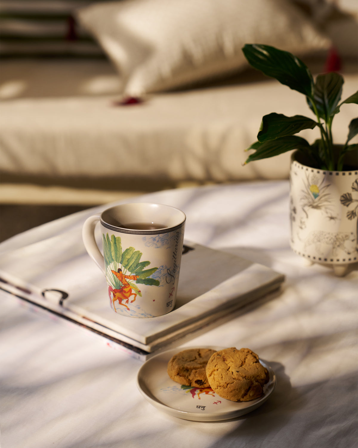 Nico Sagittarius mug and plate with tea and cookies.