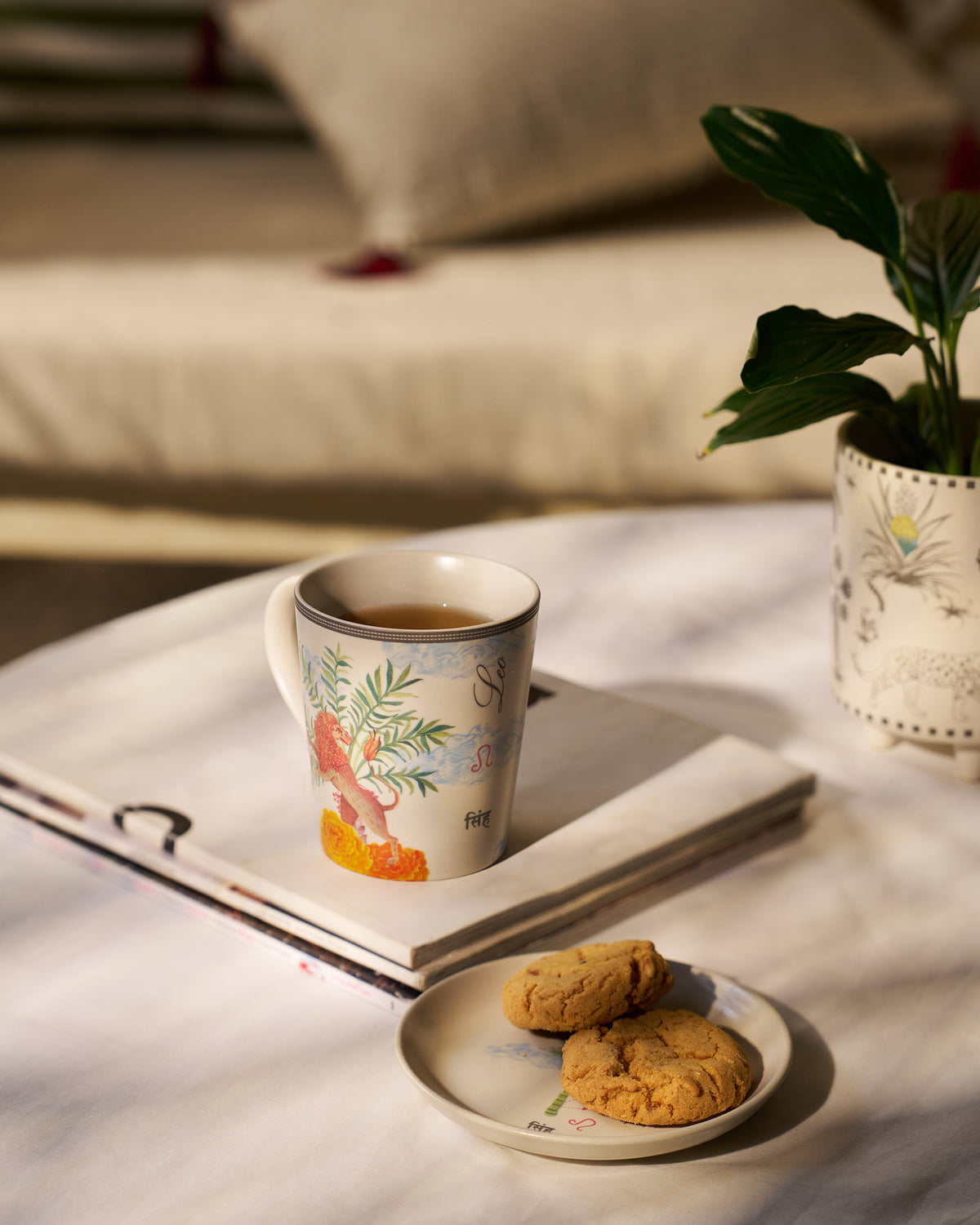 Nico Leo mug and tea plate with cookies in a sunlit setting.