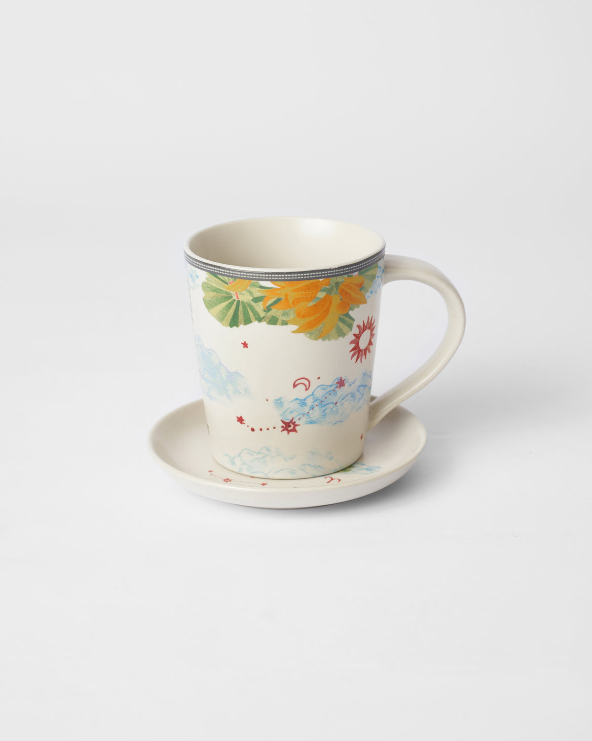 Nico Aries mug with palm leaves, flowers, and a red sun on the tea plate.