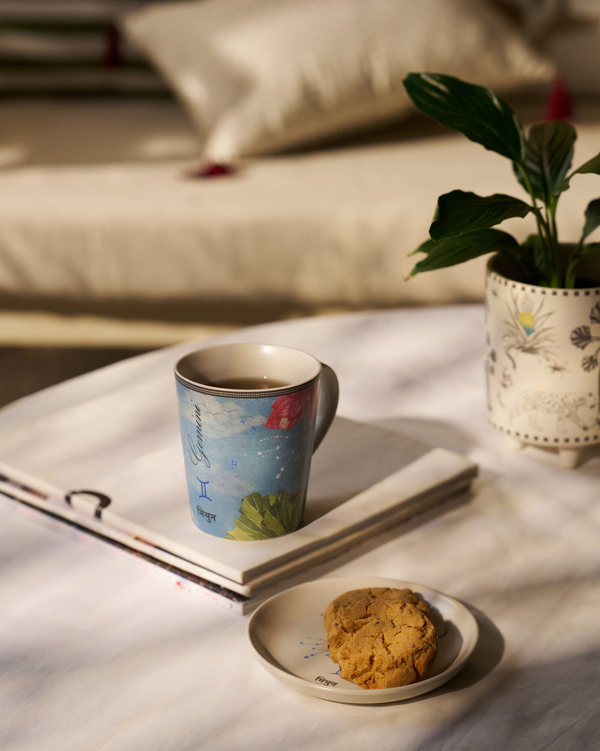 Nico Gemini mug and tea plate styled on a stack of books.