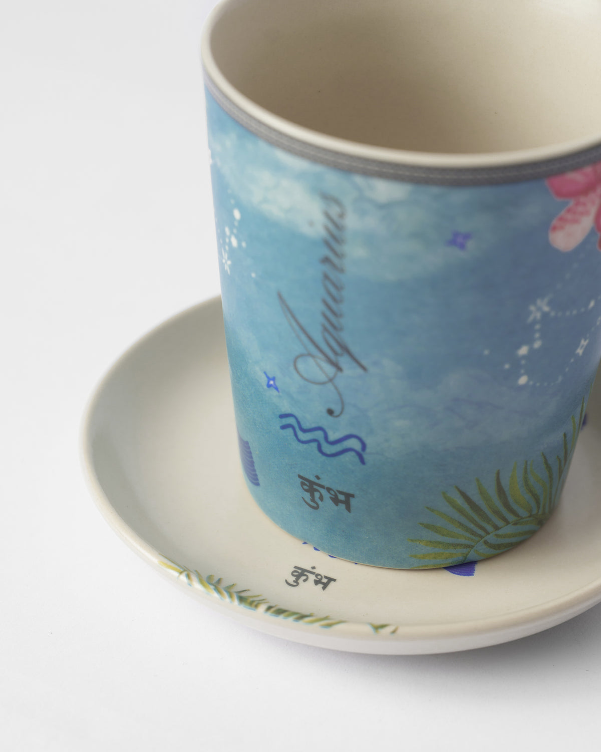 Close-up of Nico Aquarius mug and plate with कुंभ lettering.