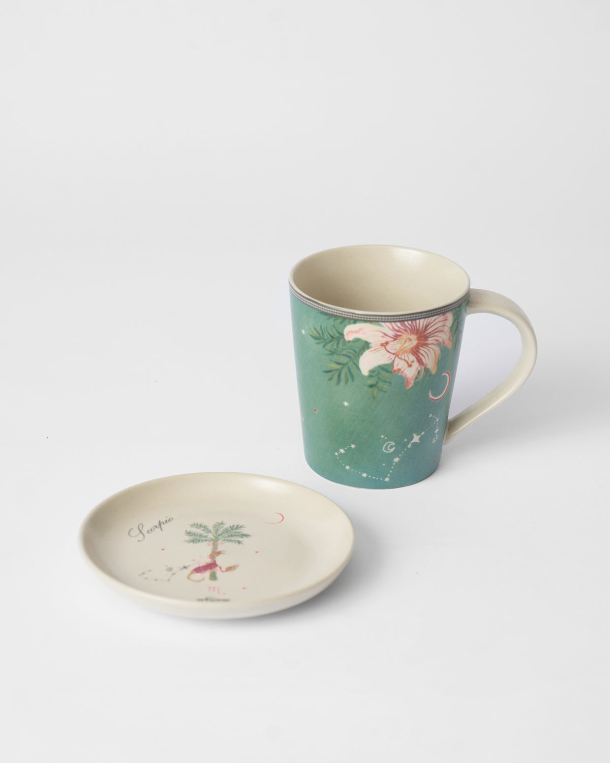 Nico Scorpio tea plate with a scorpion motif beside the teal mug.