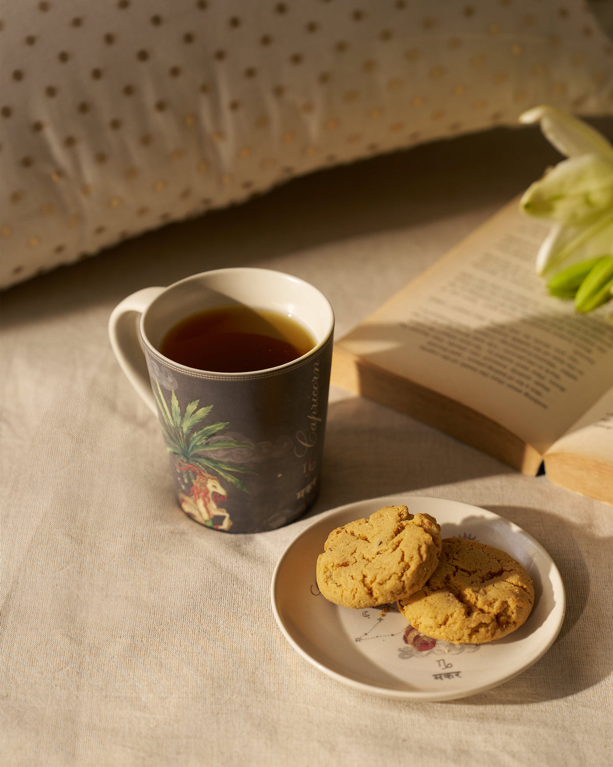 Nico Capricorn Gift Set mug and plate styled with tea and cookies.